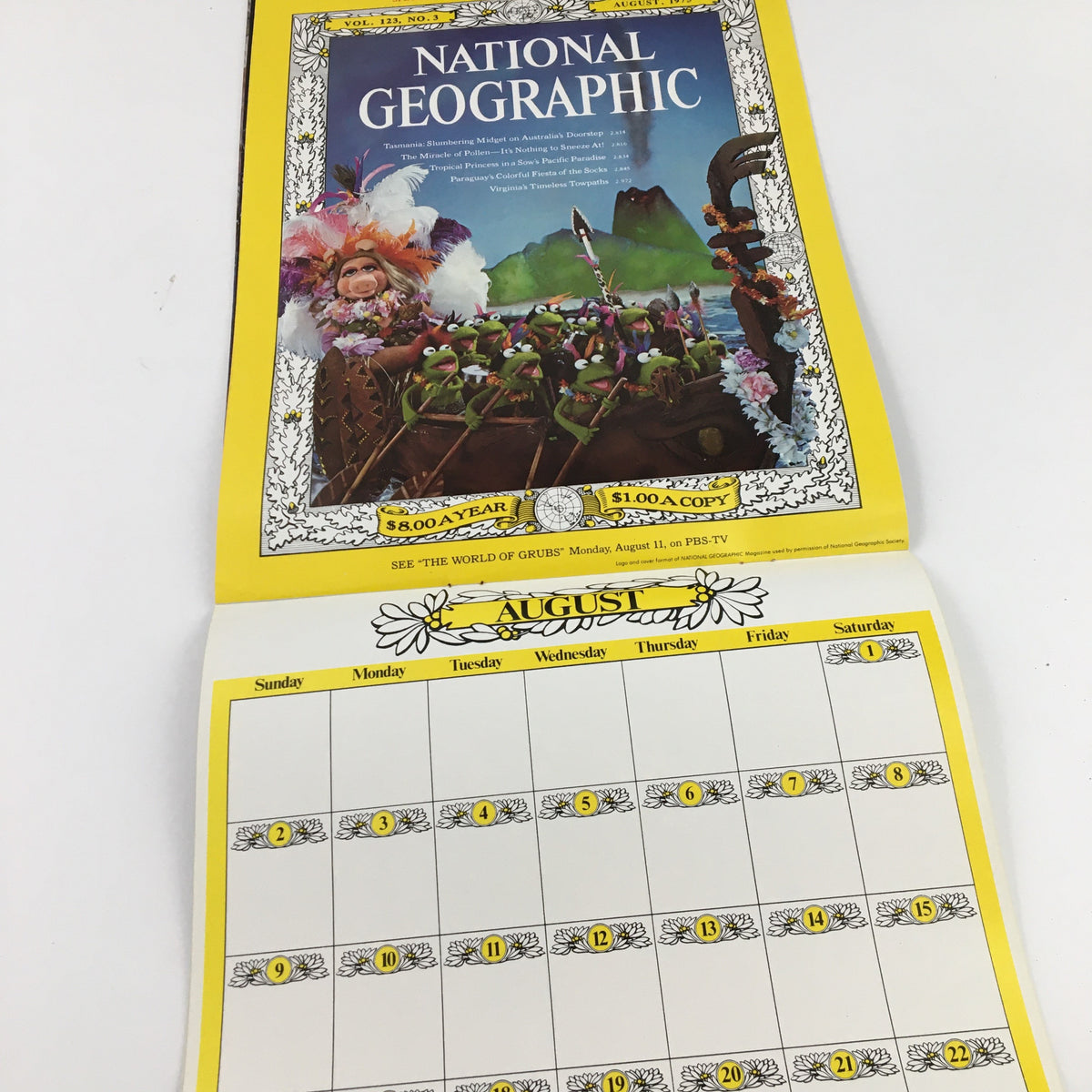 Jim Henson's Muppets Present The Miss Piggy Cover Girl Fantasy Calendar 1981. August calendar page displaying Miss Piggy on the cover of National Geographic with a vibrant, tropical background.