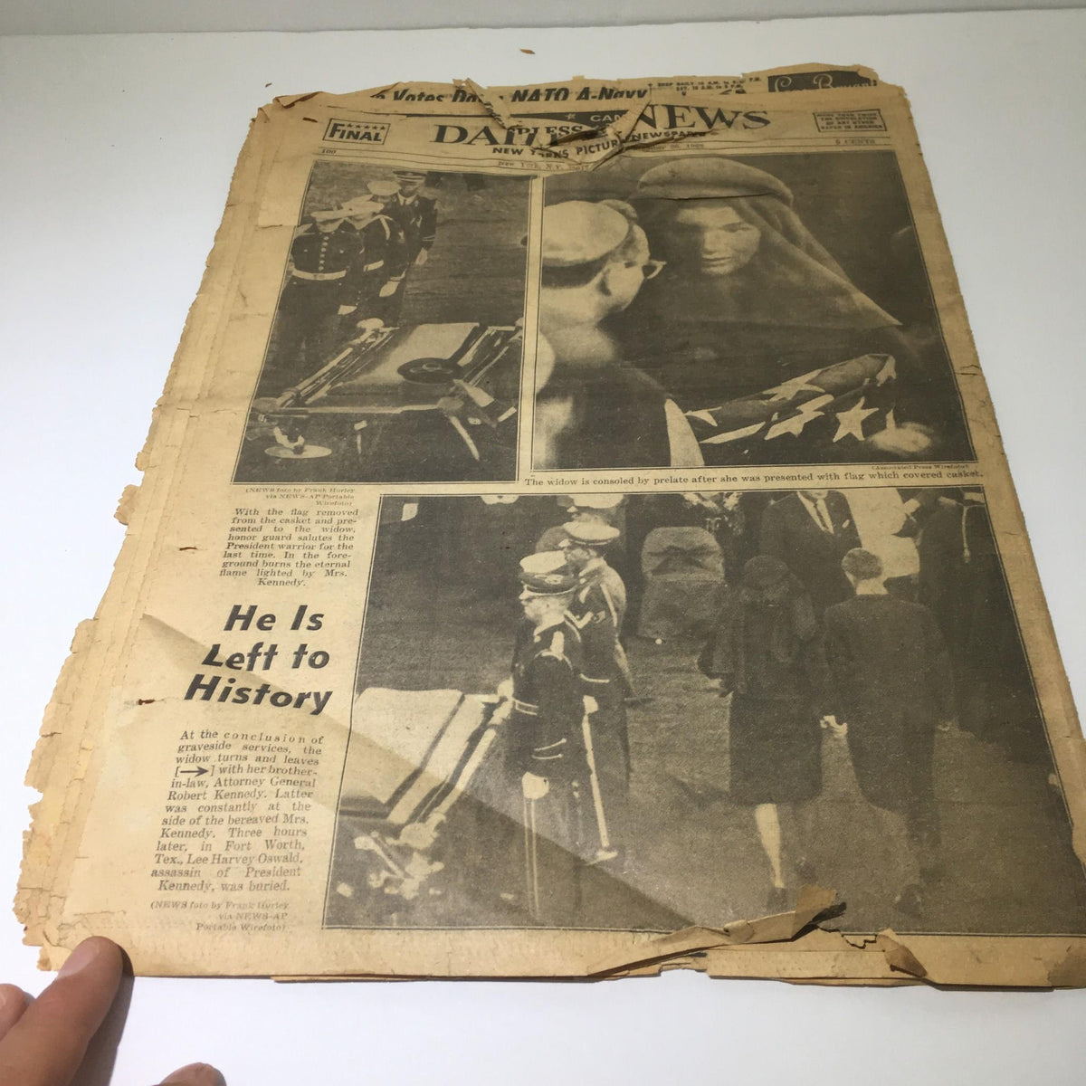 Full view of the front page of a vintage New York Daily News from November 26, 1963, titled 'We Carry On', featuring images related to JFK's funeral.
