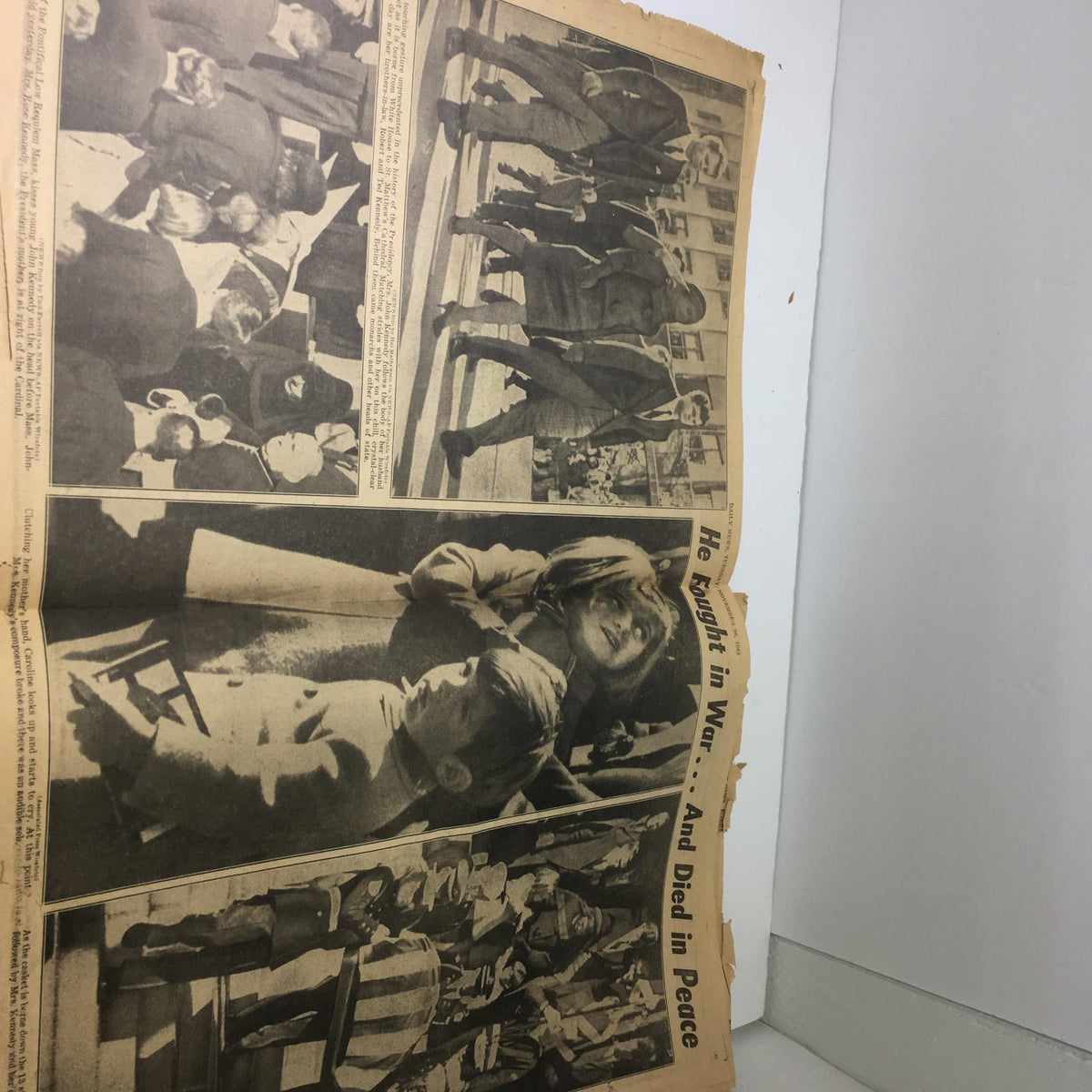 Vintage NY Daily News from November 26, 1963 capturing the scenes around JFK's funeral with poignant images of mourners, highlighting the national sorrow following his assassination.