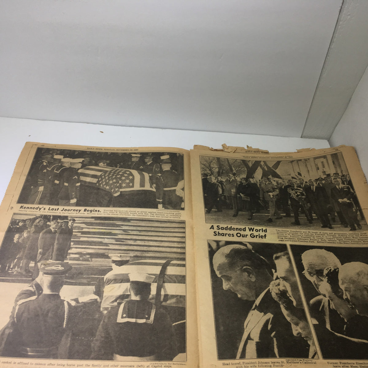 Vintage NY Daily News from November 26, 1963, featuring coverage of JFK's funeral. The image shows a military procession with soldiers carrying a flag-draped coffin, highlighting the somber moment of 'Kennedy's Last Journey Begins.'