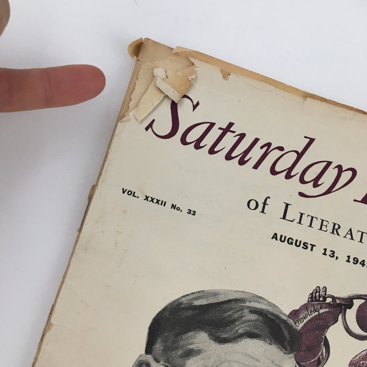 Close-up view of the damaged corner of Saturday Review Magazine, dated August 13, 1949, showcasing the magazine's vintage design and wear.