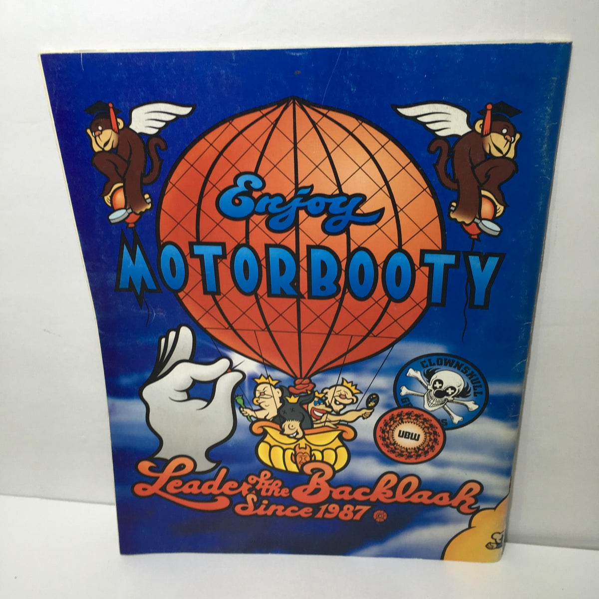 Back cover of MotorBooty Music Magazine showcasing the phrase 'Enjoy MotorBooty' with playful graphics and cartoon monkeys.