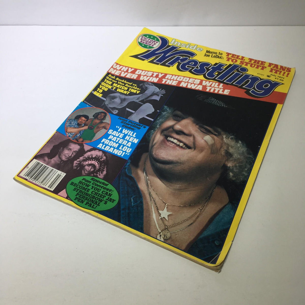 Front cover of Inside Wrestling Magazine - Victory Sports Series July 1977 featuring Dusty Rhodes in a thoughtful pose, along with various wrestling highlights and advertisements.