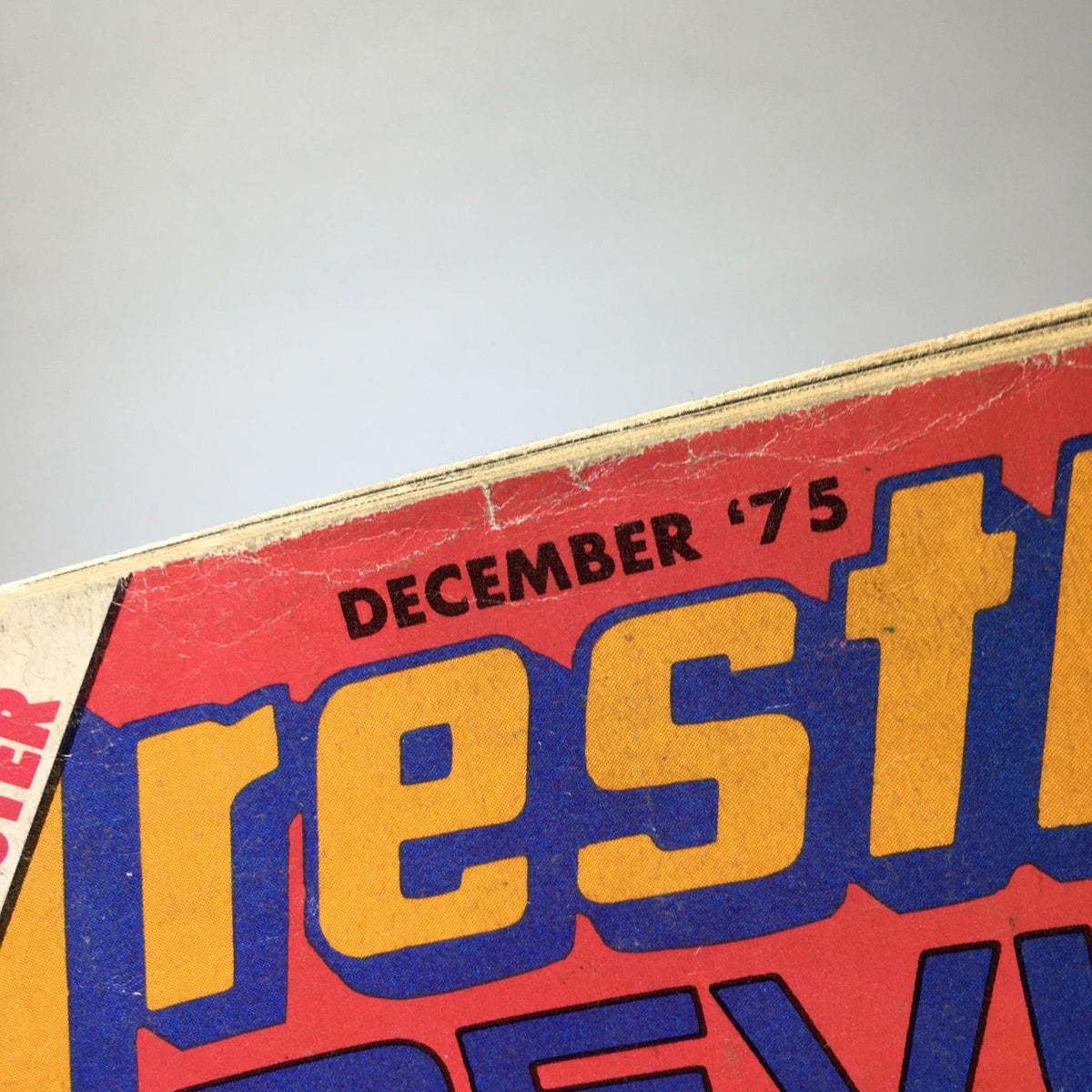 Close-up of the cover date December '75 on Wrestling Revue Magazine, showcasing its vintage design and historical significance in wrestling publications.