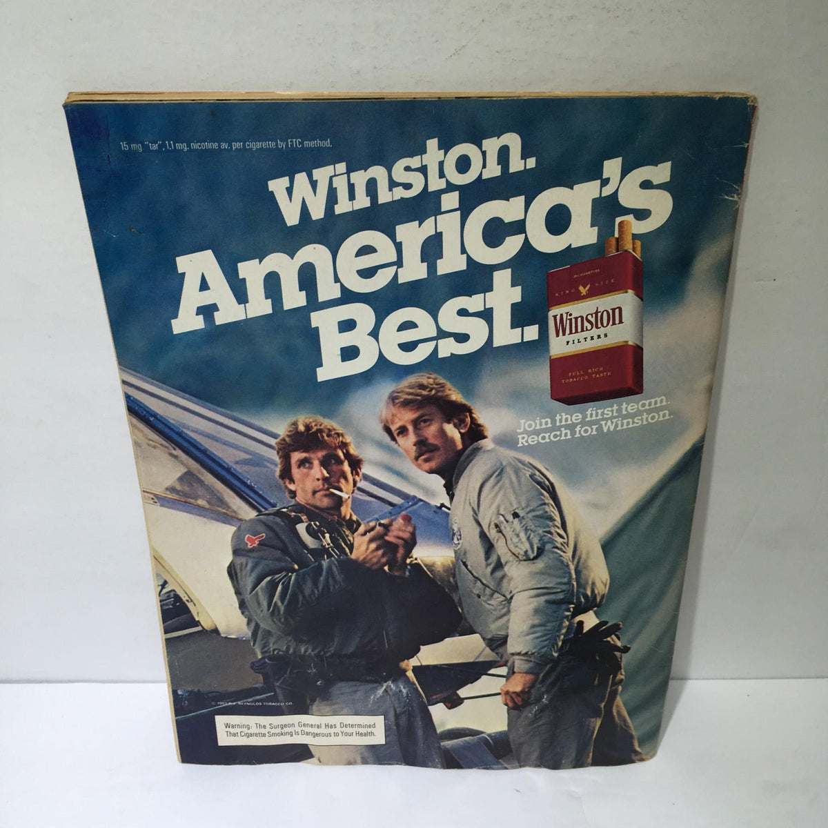 Back cover of an advertising page for Winston cigarettes, featuring two men and the slogan 'America’s Best', representative of 1980s advertising.