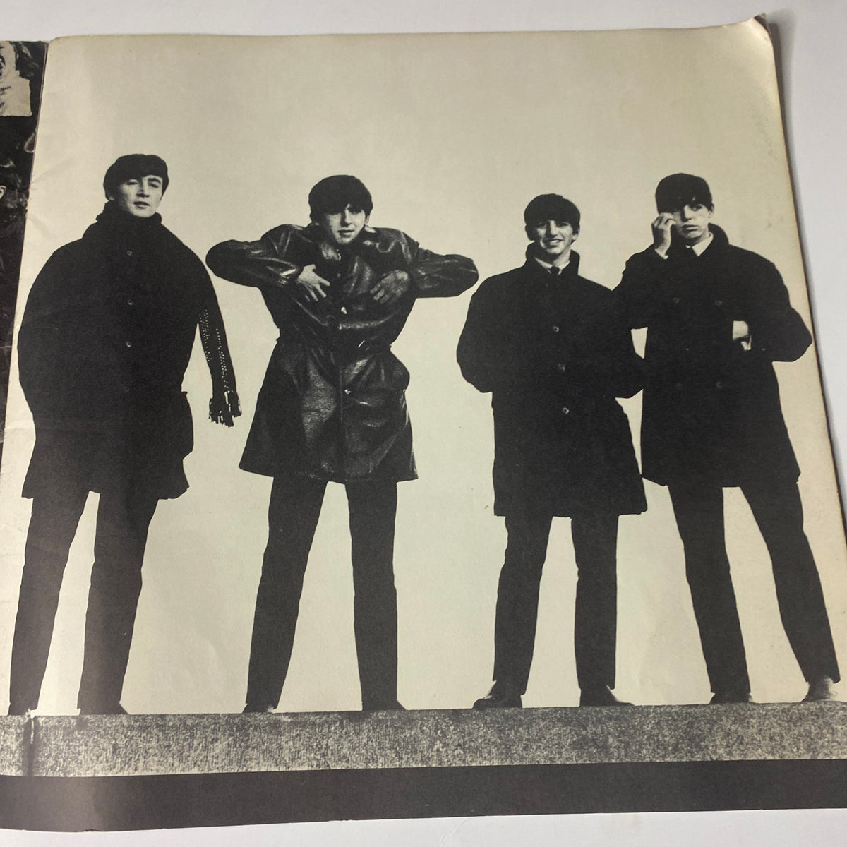 Photograph of the Beatles in casual poses included in the 1964 Beatles (U.S.A.) Ltd. Limited Tour Program Book, showcasing their iconic style.