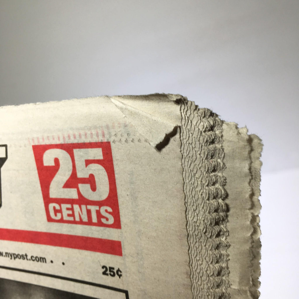 Close up of New York Post: Oct 23 2001 One More Time displaying the price '25 cents' with slight wear on the edge of the paper.