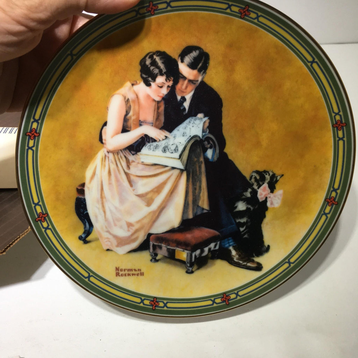 Close-up of the 1985 A Couple's Commitment by Norman Rockwell Collectible Plate #12448I featuring a couple reading together.