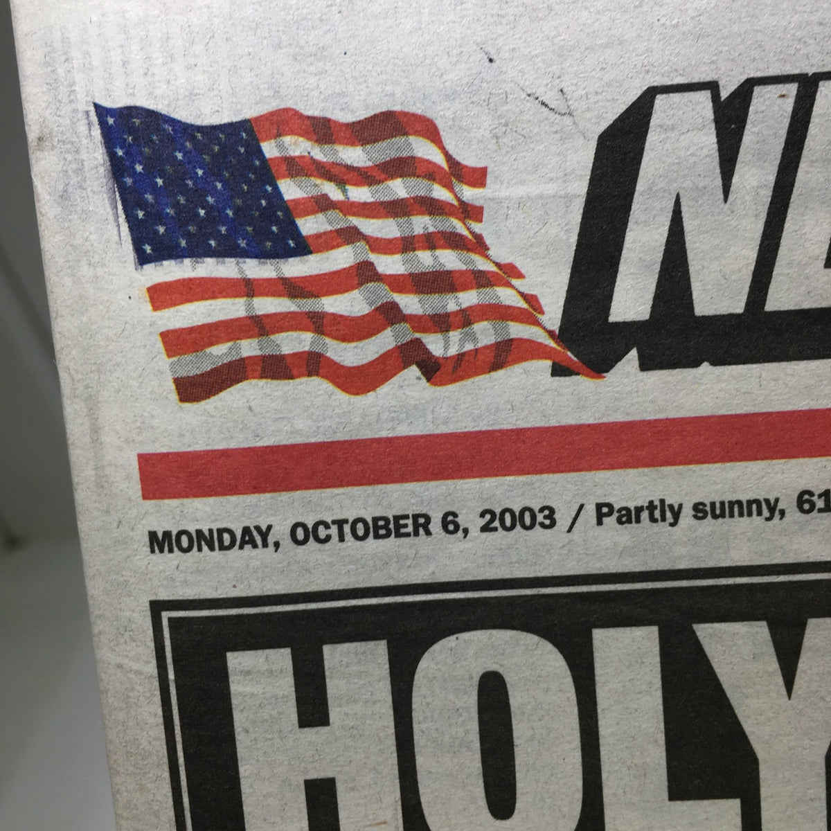 Close-up of the New York Post logo with an American flag and the date, Monday, October 6, 2003, showcasing partly sunny weather.