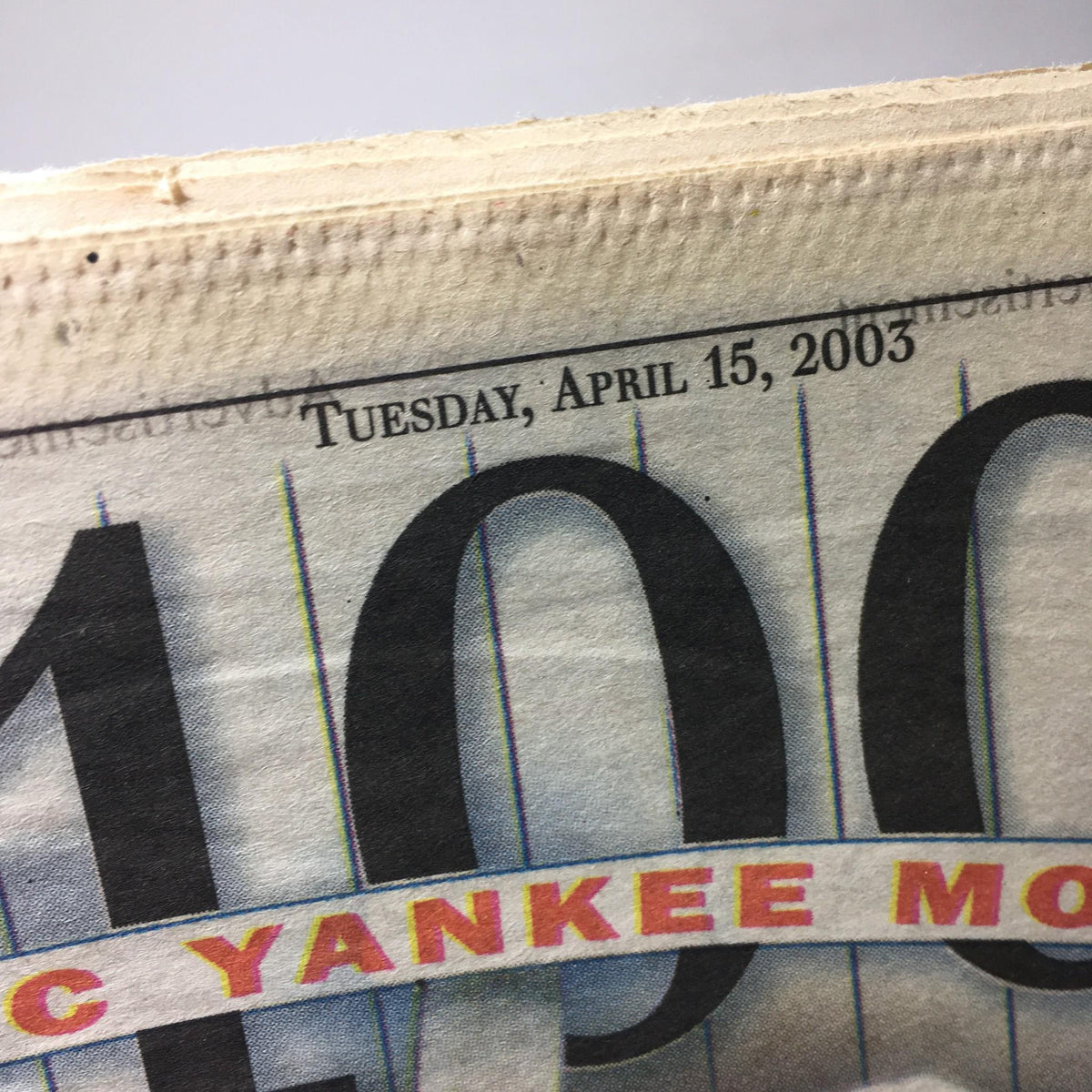 Close-up of the date 'Tuesday, April 15, 2003' printed on the New York Daily News titled 'Blue Ribbon Panel Ranks A Century Of Highlights'.