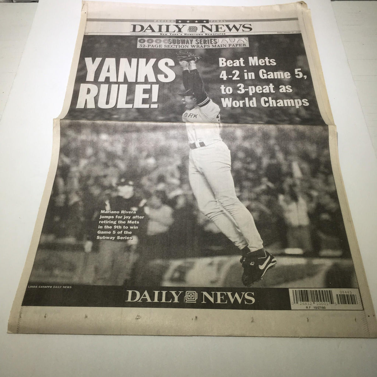 NY Daily News newspaper from October 27, 2000, featuring a headline about the New York Yankees' victory over the New York Mets in Game 5 of the Subway Series, stating 'Yanks Rule! Beat Mets 4-2 in Game 5, to 3-peat as World Champs.'