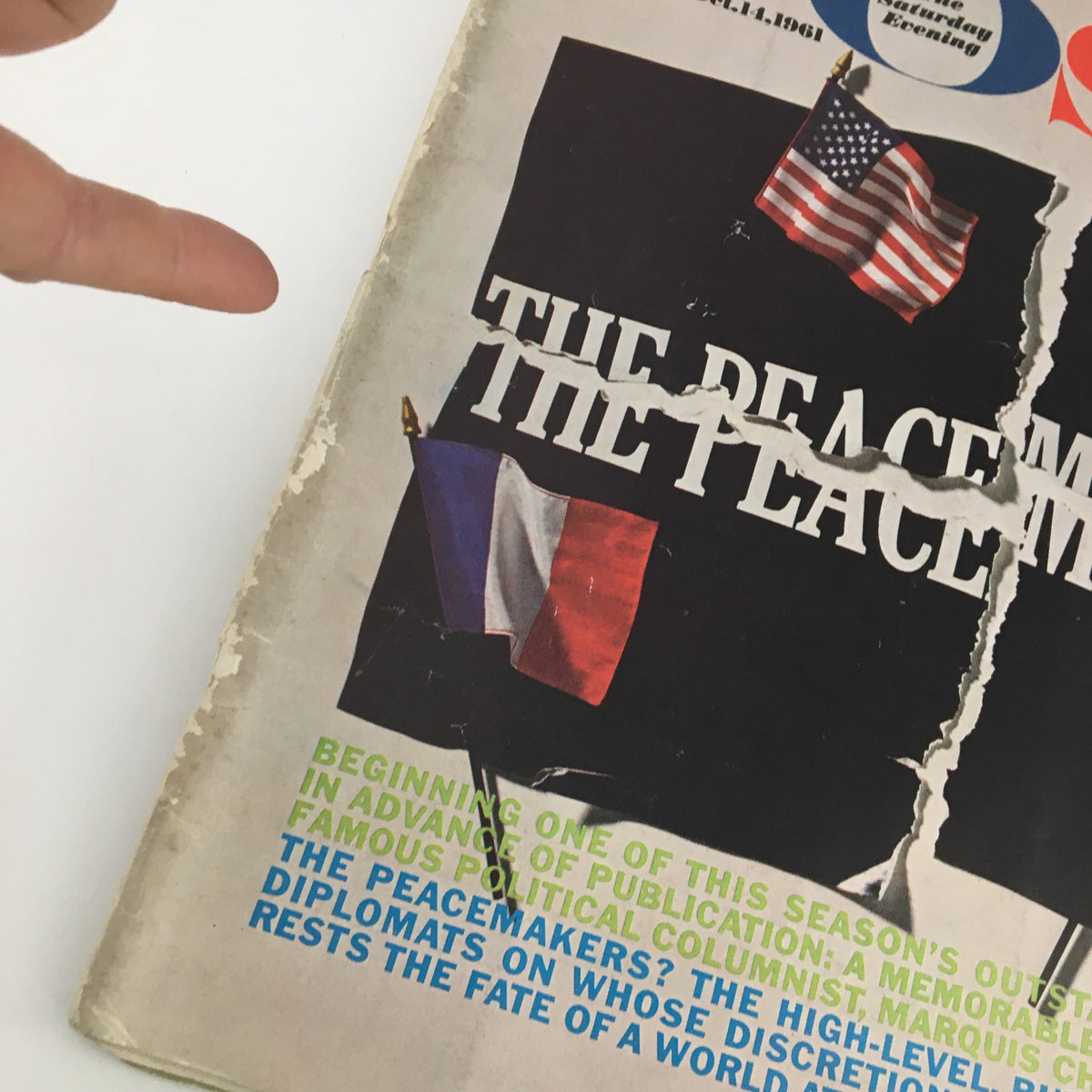 Close-up of the October 14, 1961 cover of The Saturday Evening Post, highlighting the title 'The Peacemakers,' with flags and visible wear, emphasizing its vintage charm.