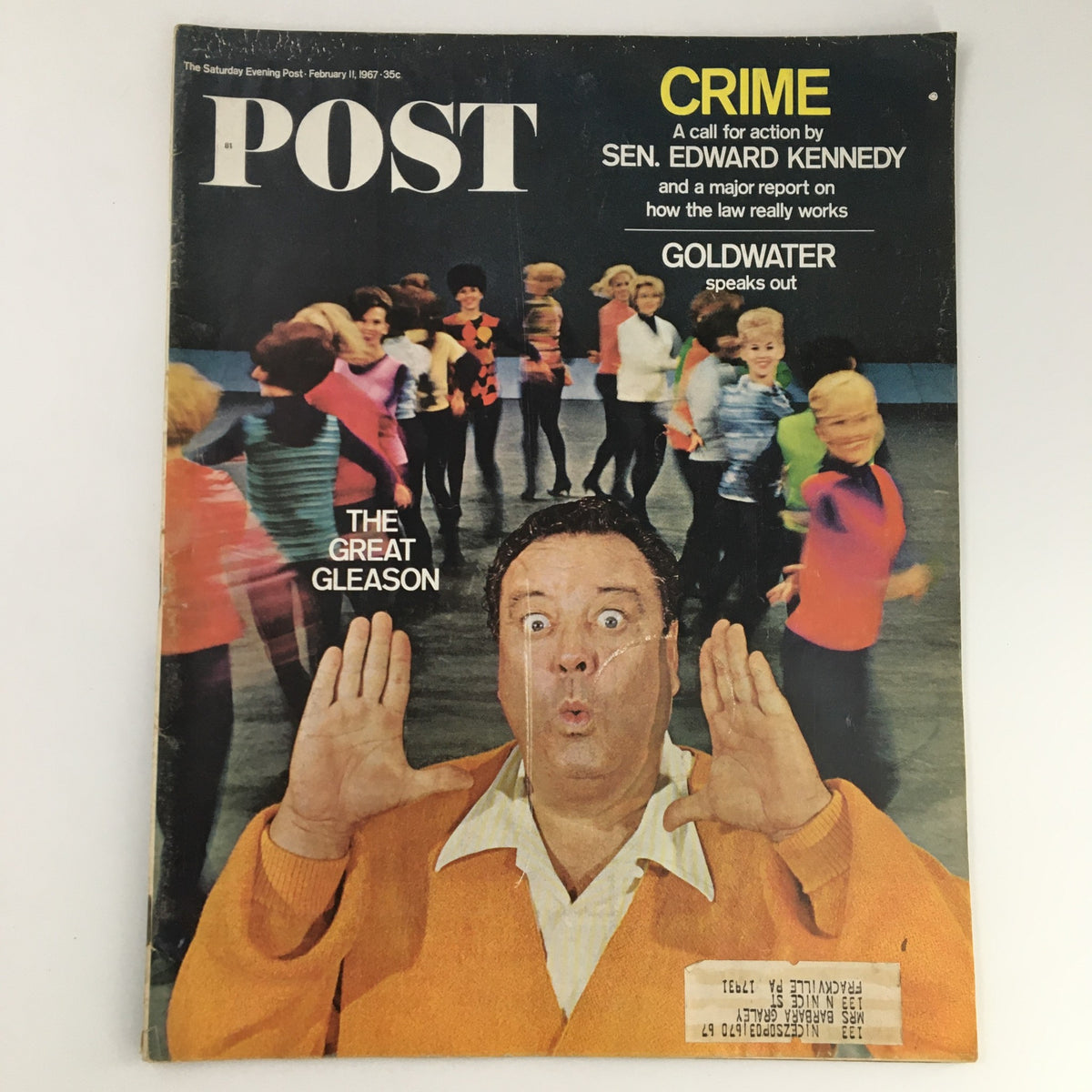 The Saturday Evening Post February 11 1967 featuring Edward Kennedy and Barry Goldwater, with a playful cover illustration showing a surprised man in an orange sweater surrounded by dancing children.