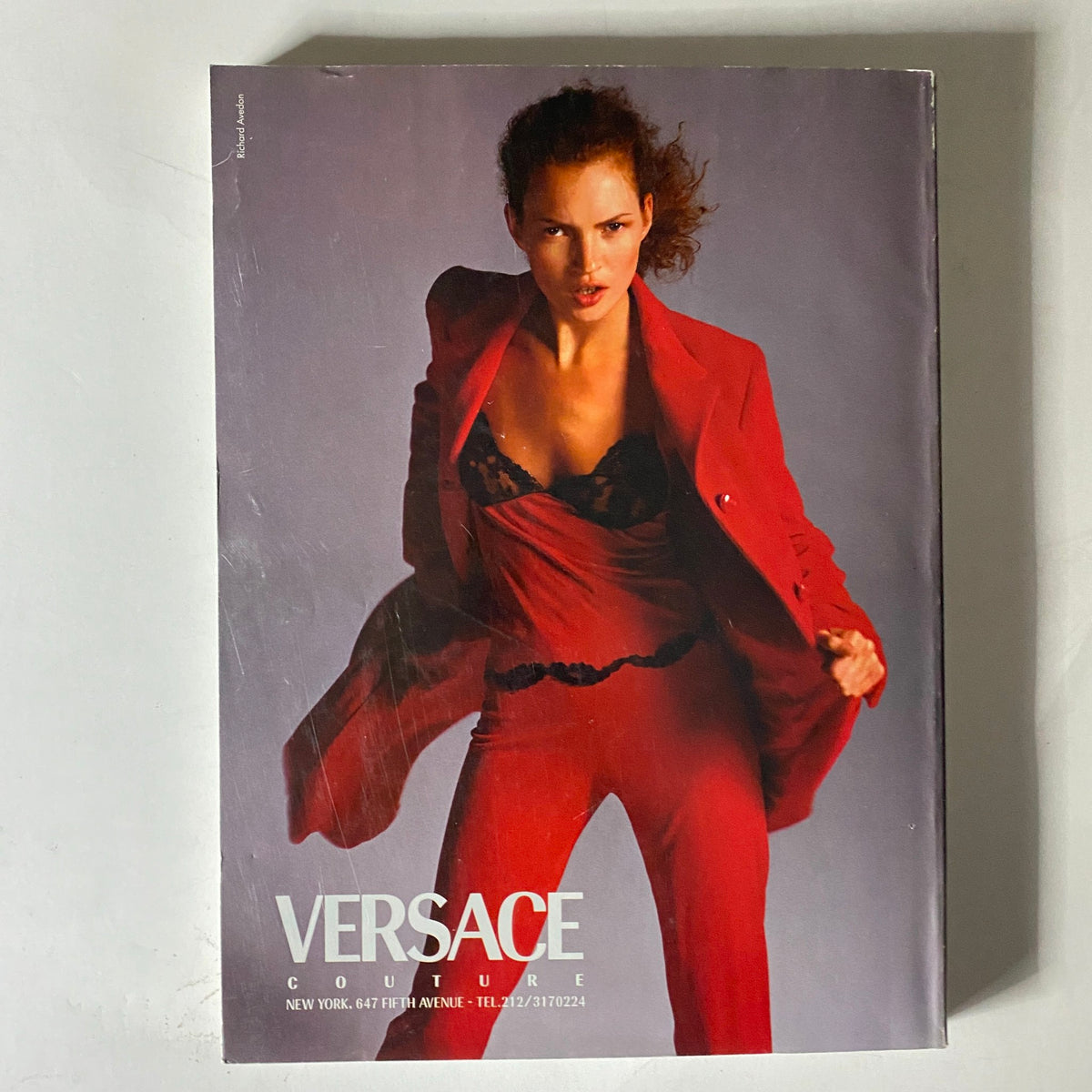 Cover of Versace Couture magazine featuring a model in a striking red ensemble, emphasizing high fashion trends of the 1990s.