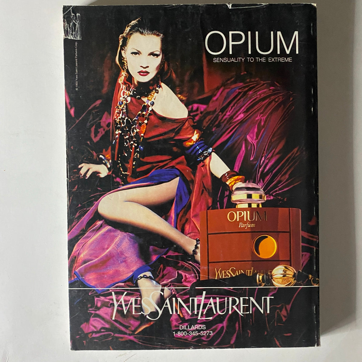 Cover of Yves Saint Laurent's Opium advertisement from Vogue Magazine November 1994, highlighting the luxury perfume with a model dressed in glamorous fashion.
