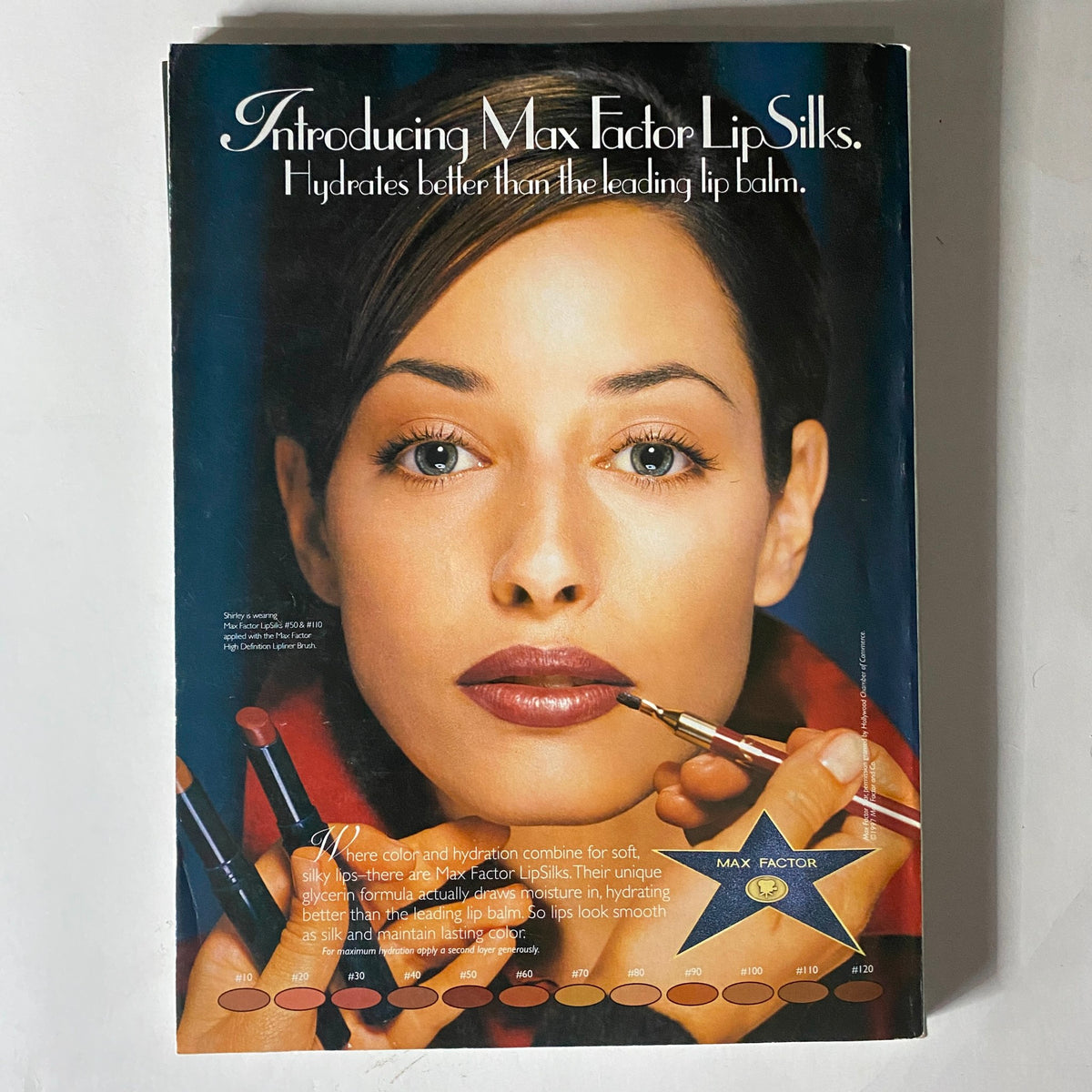 Advertisement from Vogue Magazine August 1997 introducing Max Factor LipSilks, featuring a close-up of a woman's face showcasing a beauty product. The advertisement highlights the benefits of lip hydration and color, reflecting the beauty trends of the late 90s.