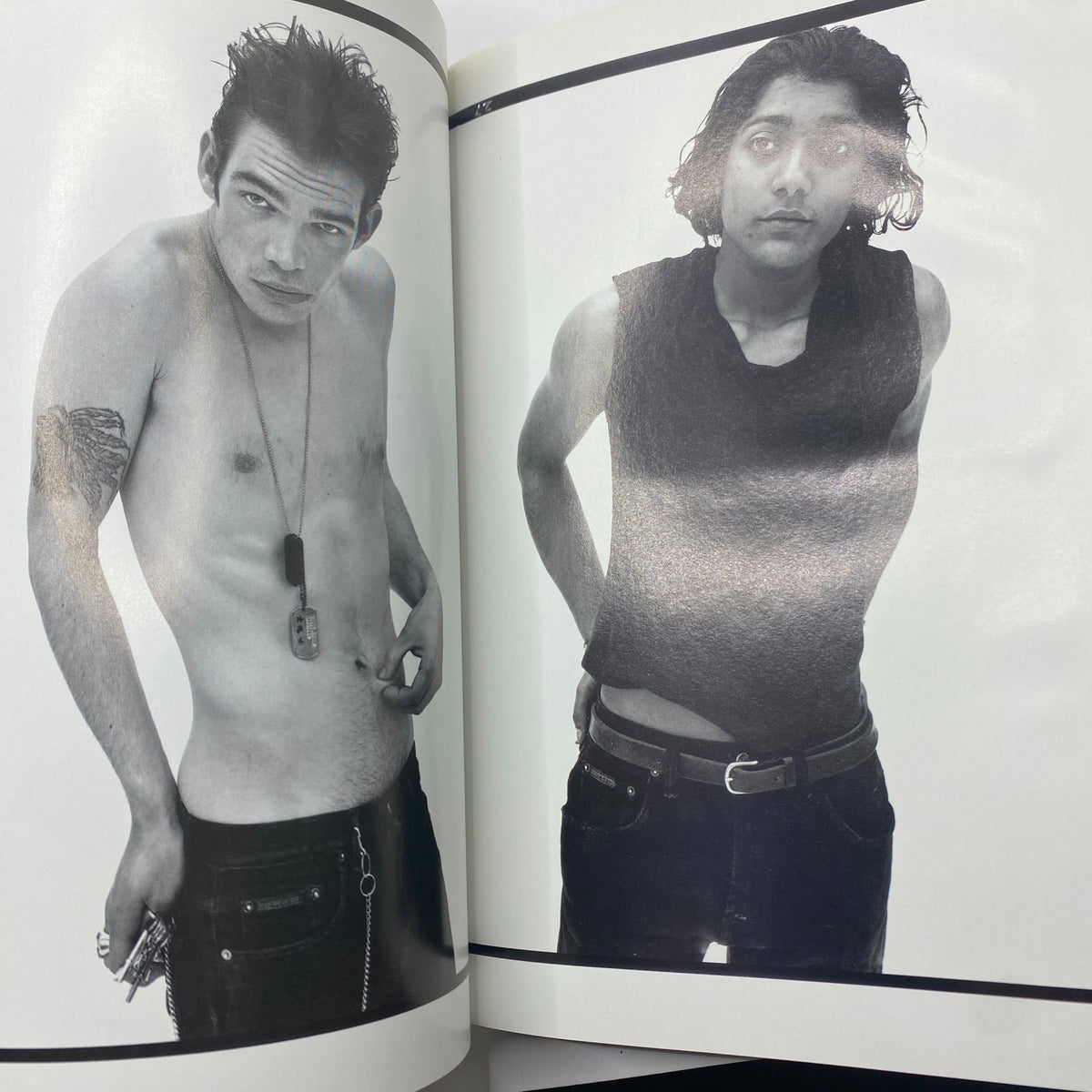 Black and white photo from within Vogue Magazine featuring two male models posing creatively, showcasing edgy fashion styles.