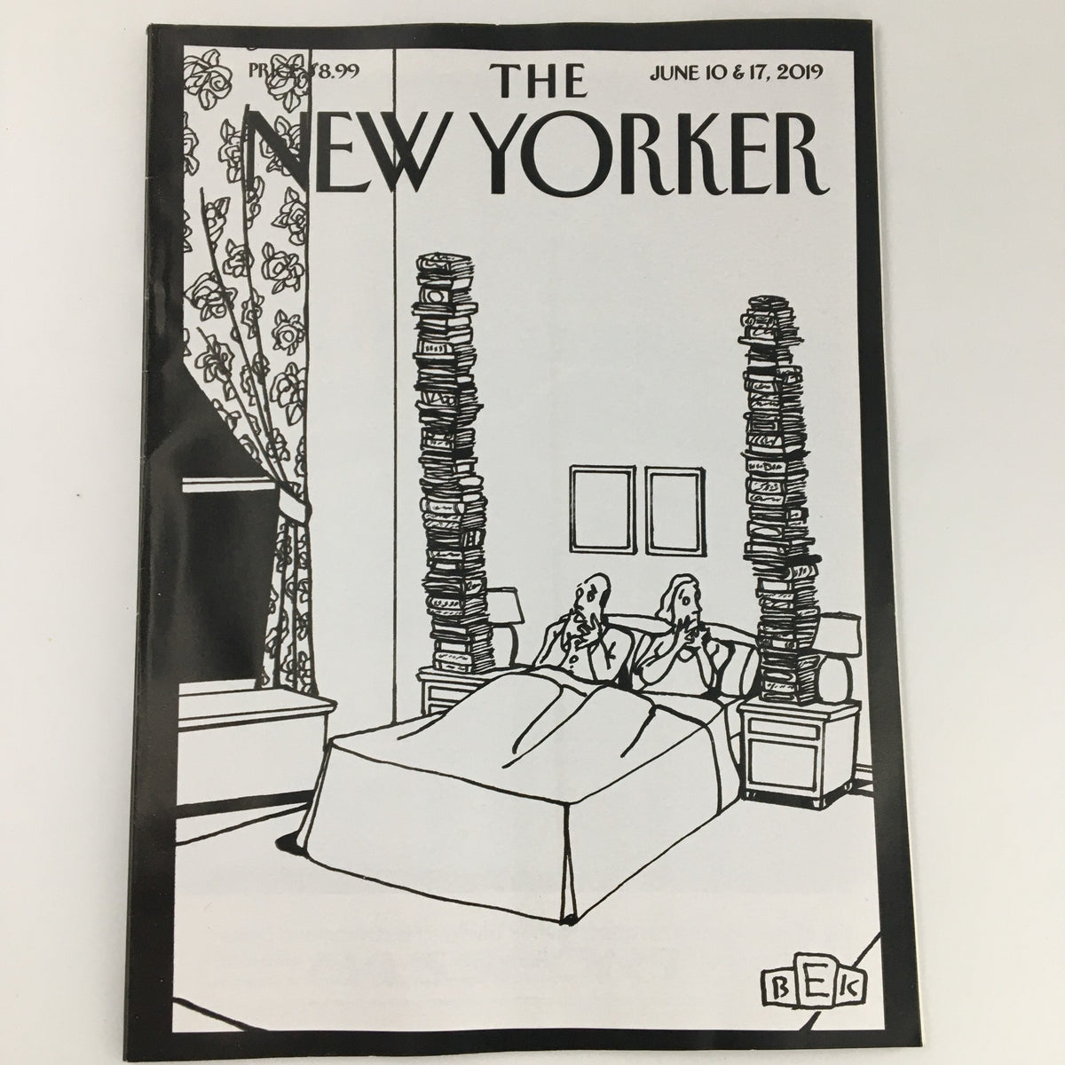The New Yorker June 10 & 17 2019 magazine cover featuring a whimsical illustration by Bruce Erik Kaplan, depicting two figures in bed surrounded by towering stacks of books, emphasizing the theme of reading and culture.
