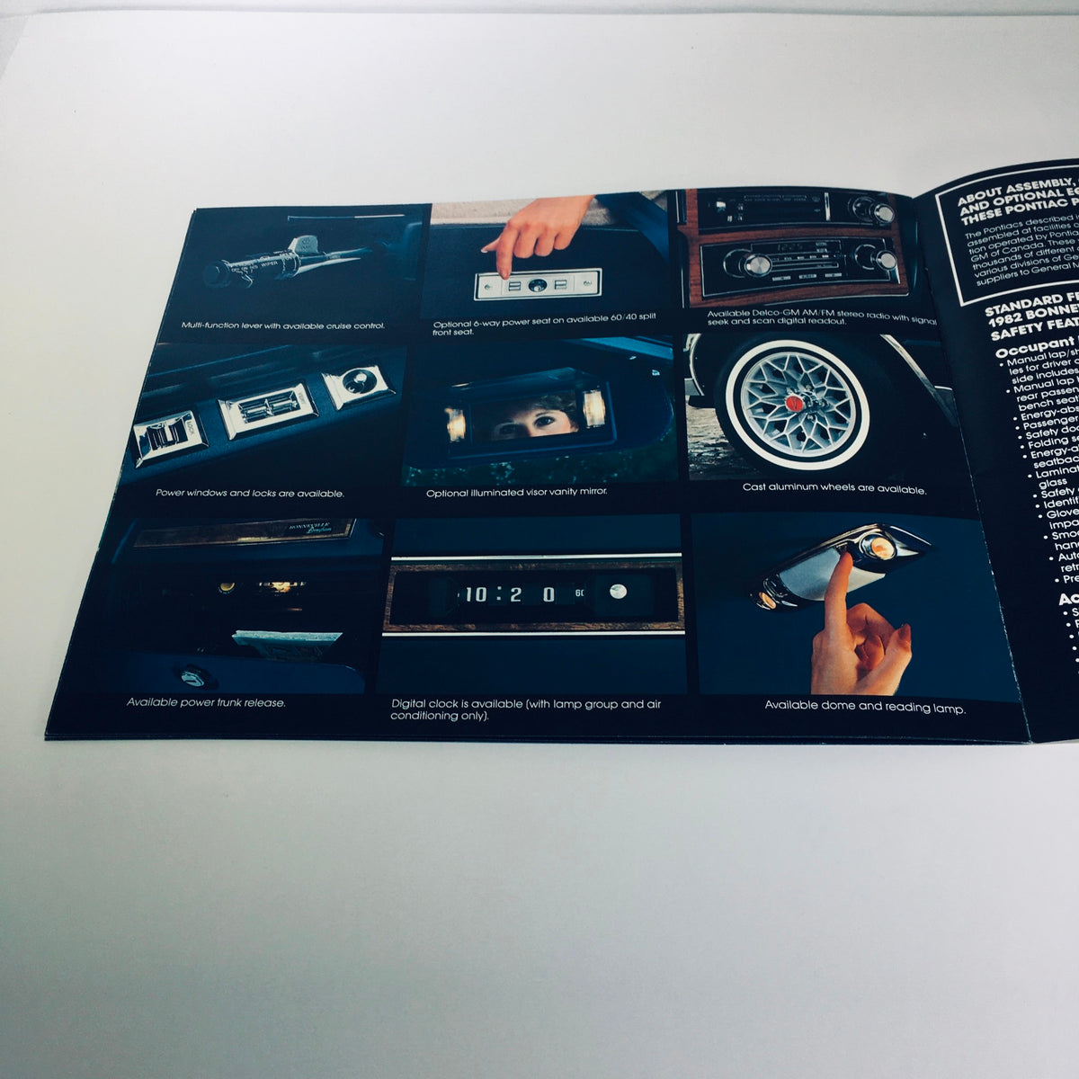Interior features of the 1982 Pontiac Bonneville Model G Brougham 4-Door Sedan highlighted in the car sales brochure, showcasing luxury options like a multi-function radio, digital clock and available aluminum wheels.