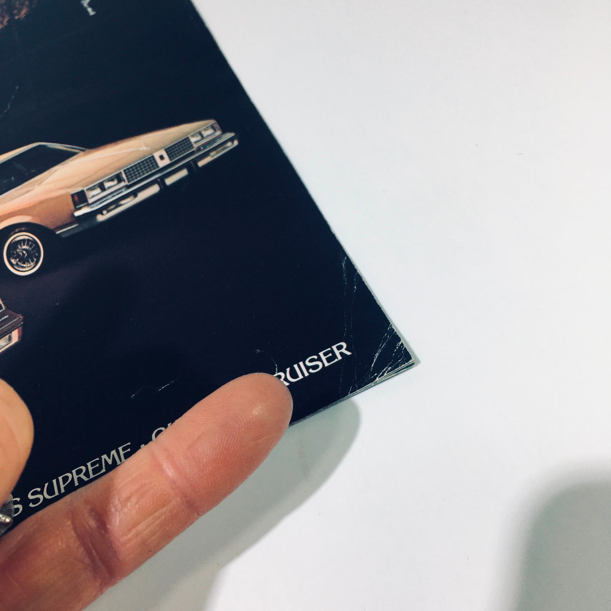 Close-up of the 1982 Oldsmobile Cutlass Supreme & Cutlass Cruiser sales brochure highlighting minor wear, showcasing the brochure's vintage quality.