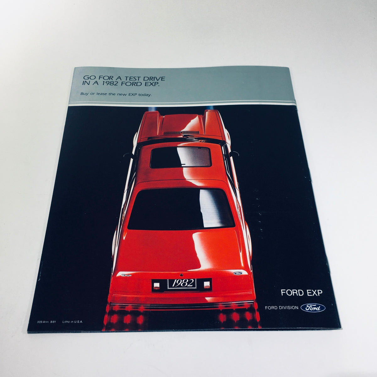 Back cover of the 1982 Ford Exp Two-Seat Hatchback World-Class Coupe brochure encouraging a test drive of the red Ford EXP.