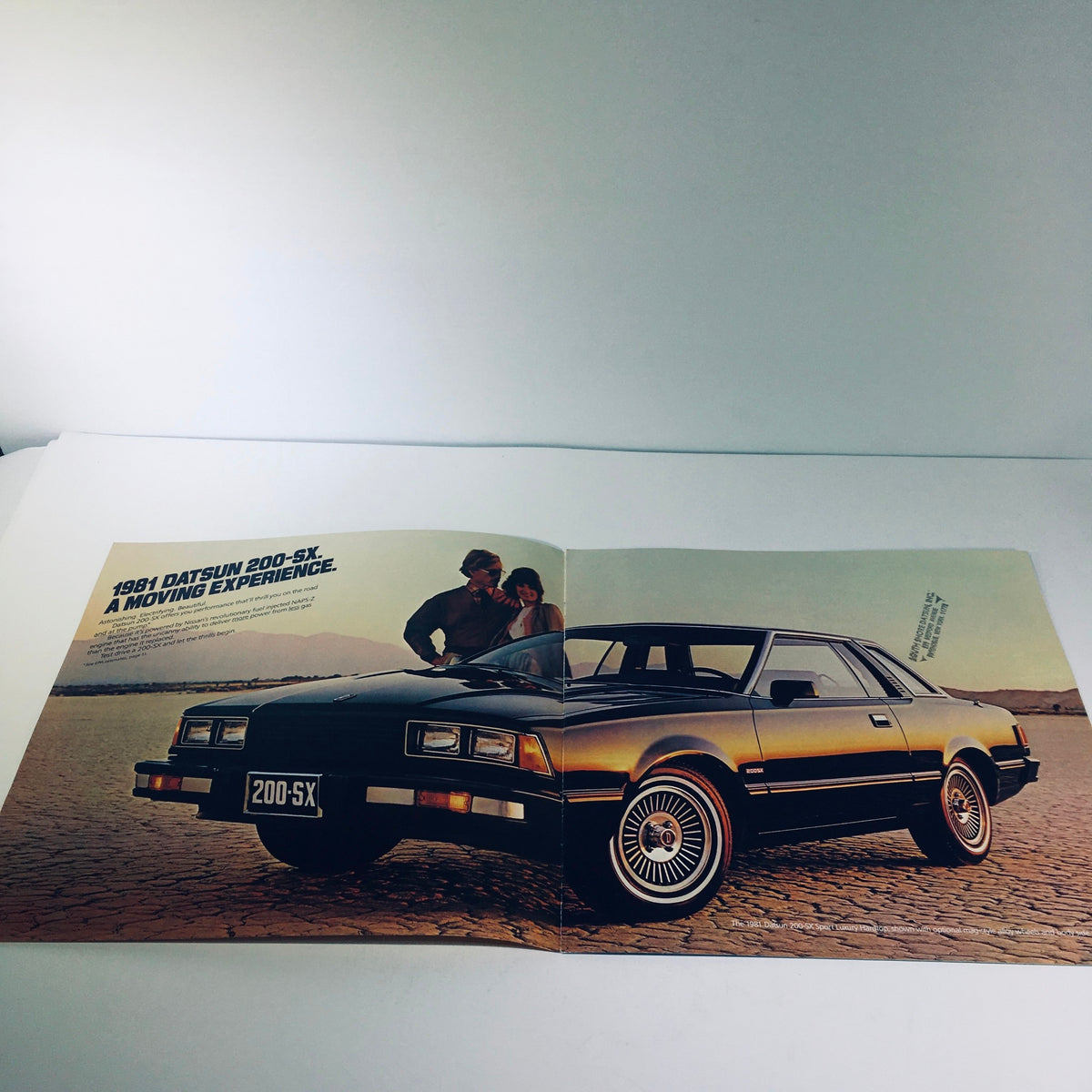 Inside view of the 1981 Datsun 200-SX by Nissan Fuel Injected NAPS-Z Car Sale Brochure, showcasing a couple beside the car with the text '1981 Datsun 200-SX, A Moving Experience.'