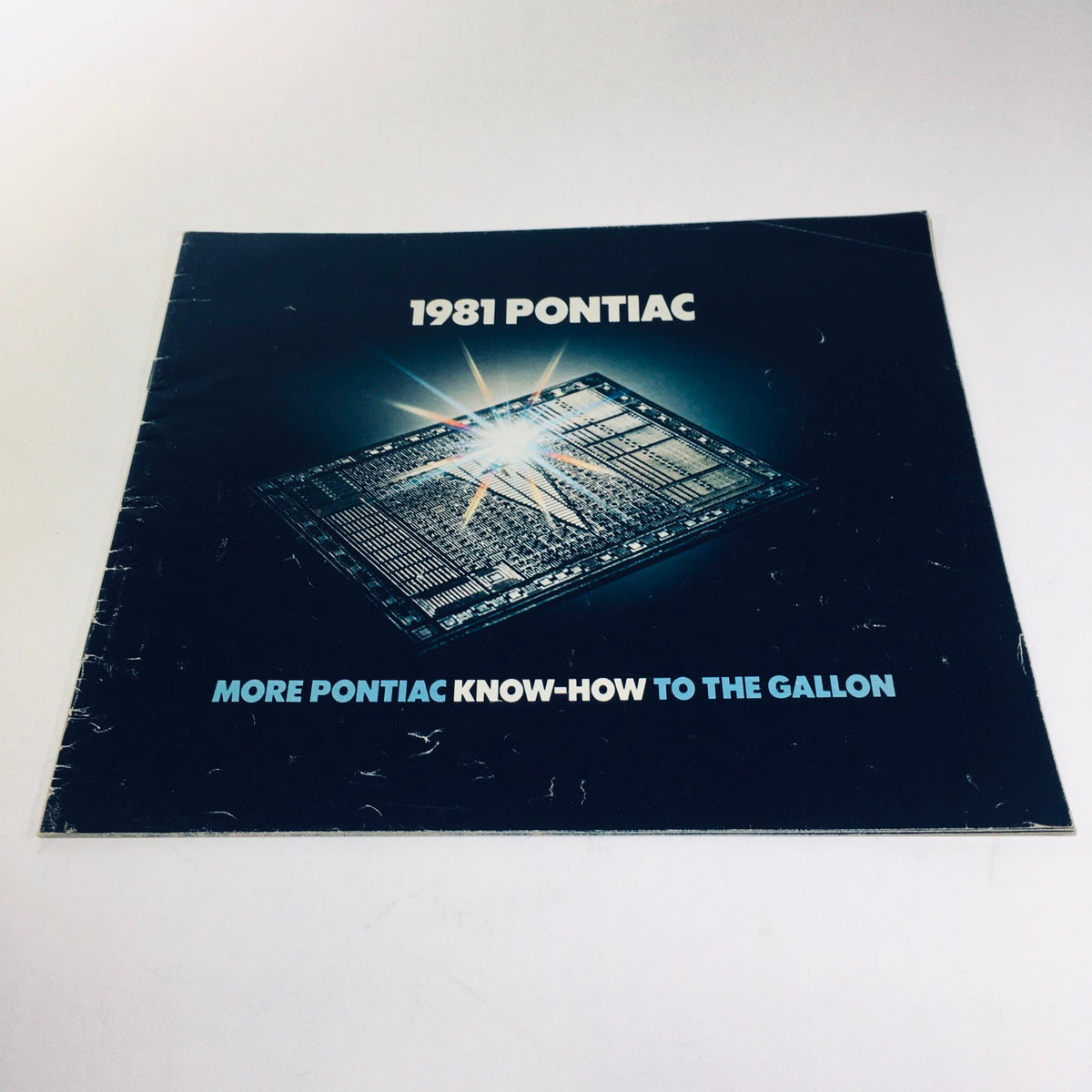 Cover of the 1981 Pontiac Firebird & Le Mans GM-Built Engines Roto in U.S.A Car Sale Brochure, featuring a starburst design and the text 'More Pontiac Know-How to the Gallon'.