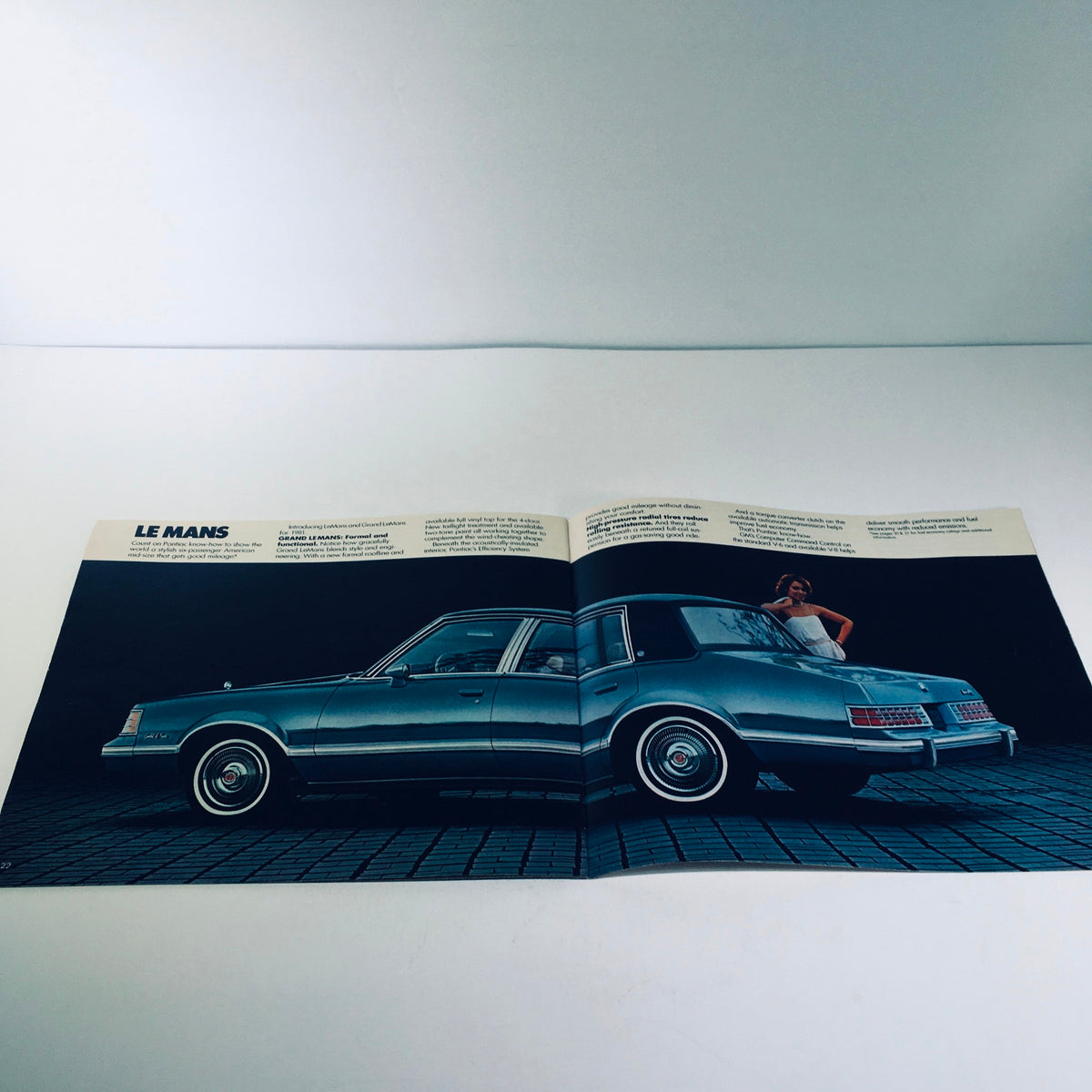 Interior spread of the 1981 Pontiac Firebird & Le Mans GM-Built Engines Roto in U.S.A Car Sale Brochure, displaying the Pontiac Le Mans with a model posing nearby.
