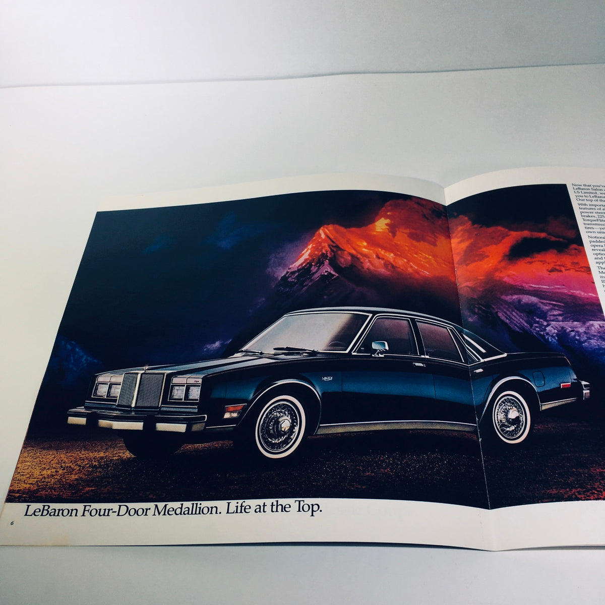 Interior page of the 1980 Chrysler LeBaron Four-Door Medallion MOPAR Parts Car Sale Brochure showcasing a blue Chrysler LeBaron in a scenic mountainous backdrop.