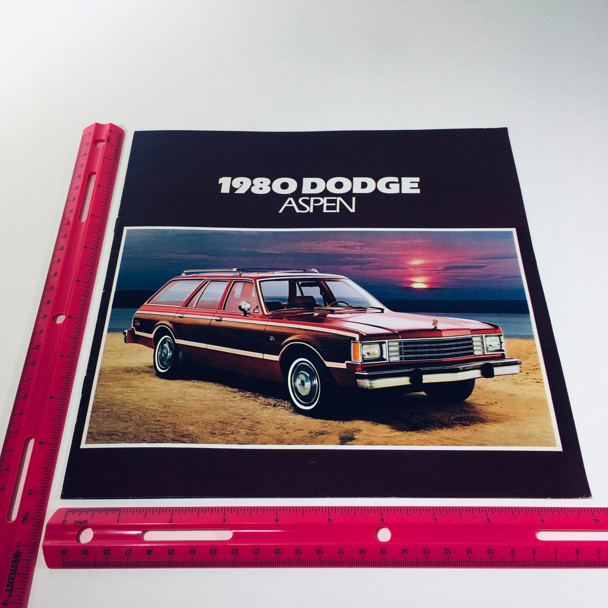Cover page of the 1980 Dodge Aspen brochure highlighting the car's features with a striking image of the vehicle against a sunset backdrop.
