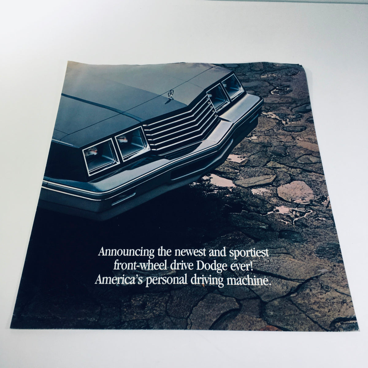 1982 Dodge 400 in Charcoal Silver Vinyl Roof Personal Luxury Car Sale Brochure, showcasing the front view of the vehicle with a modern and sporty design, and the text announcing it as America’s personal driving machine.