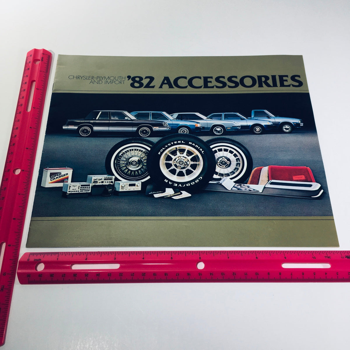 Front cover of the 1982 Chrysler-Plymouth Arrow Sport and Import Accessories Car Sale Brochure displaying accessories and vehicles, with a ruler for size reference.