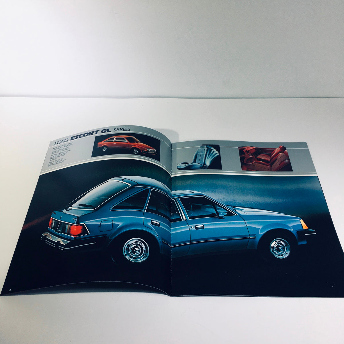Interior spread of the 1982 Ford Escort GL Series brochure highlighting features, showcasing a blue hatchback and color options.