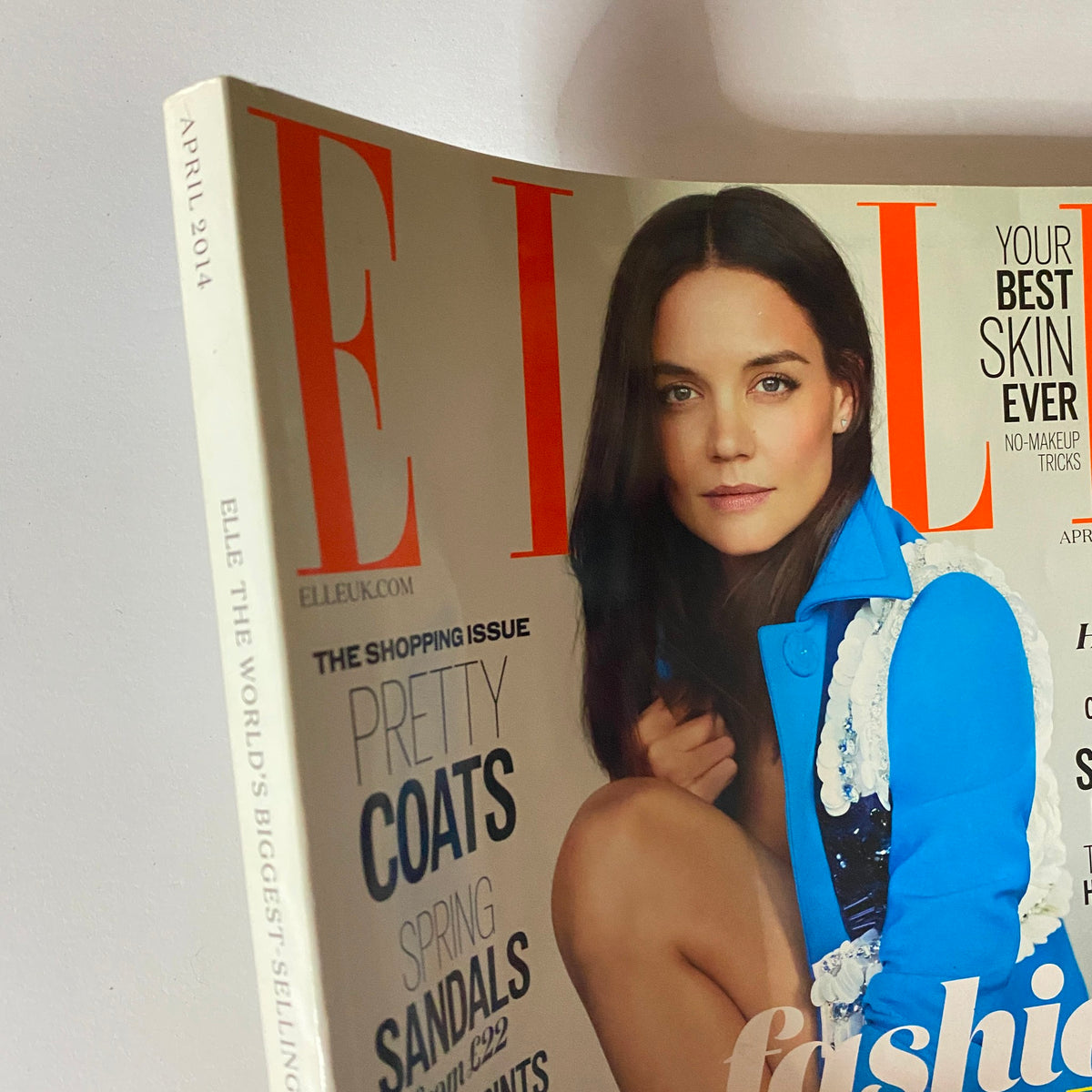 Close-up of the Elle UK Magazine April 2014 cover with Katie Holmes, highlighting fashion elements like her blue coat and showcasing text about the magazine's stylish features.