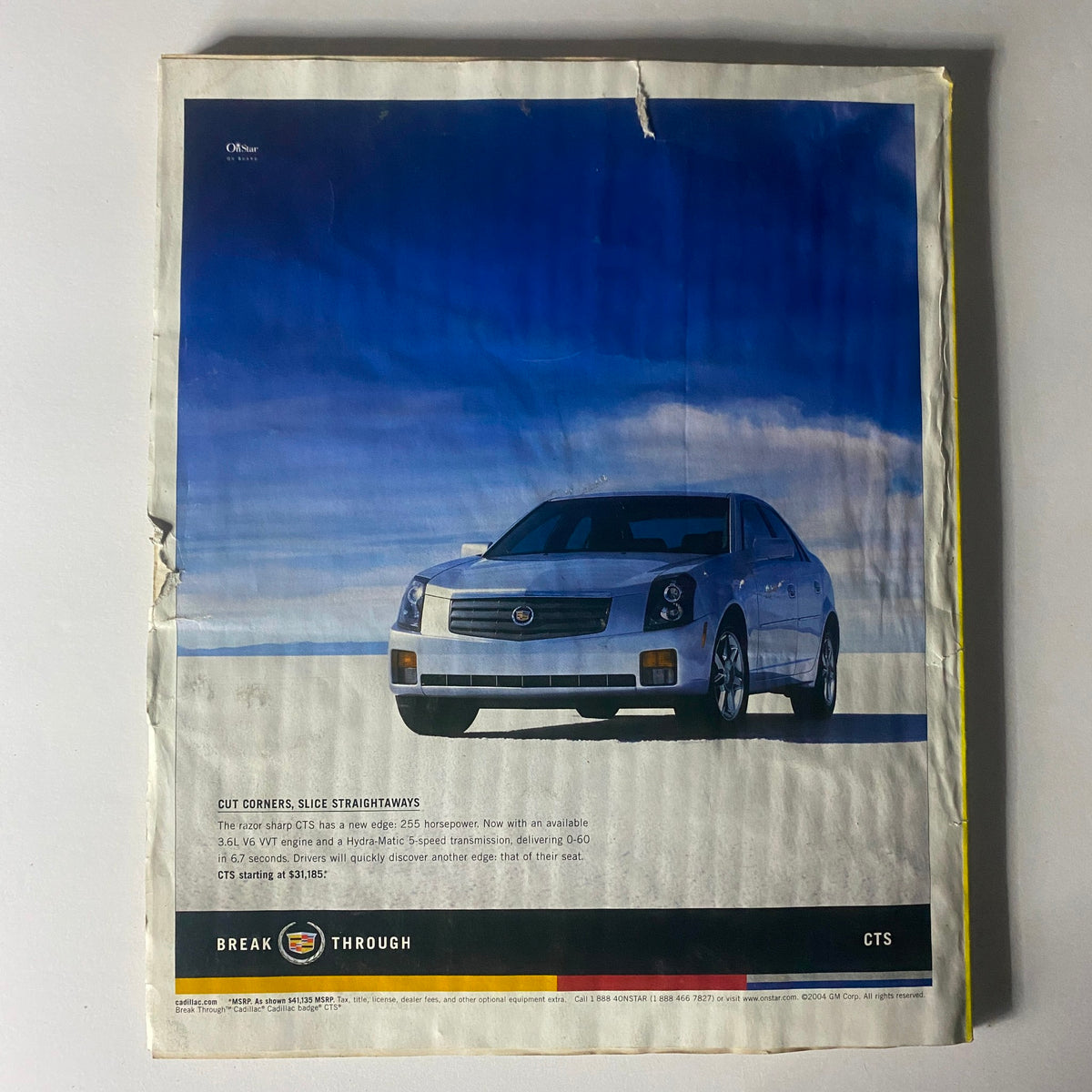 Automobile advertisement from Interview Magazine March 2004, featuring a silver Cadillac CTS on a minimalist background, emphasizing modern vehicle design.