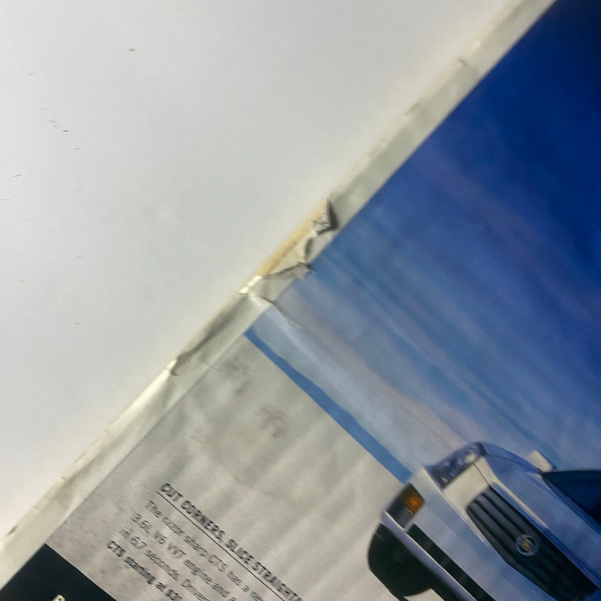 Detail of an automobile advertisement from Interview Magazine March 2004, showing a close-up of a Cadillac CTS with a faded edge, capturing the essence of mid-2000s automobile advertising.
