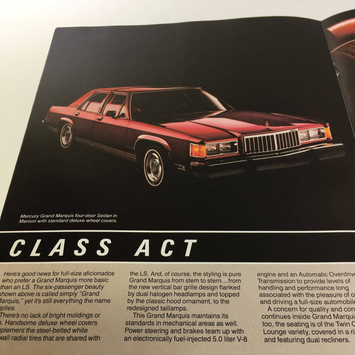 1983 Mercury Grand Marquis Class Act Fuel-Injected 5.0 L V-8 Engine Car brochure featuring a red four-door sedan with standard diffused wheel covers.