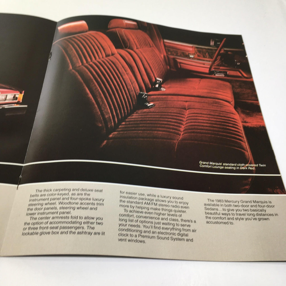 Interior view of the 1983 Mercury Grand Marquis Class Act Fuel-Injected 5.0 L V-8 Engine Car brochure showcasing luxury red upholstery in the rear seating area.