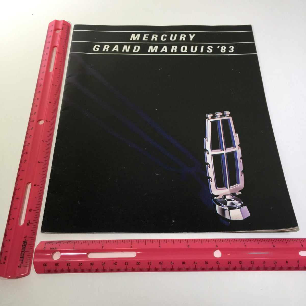1983 Mercury Grand Marquis Class Act Fuel-Injected 5.0 L V-8 Engine Car brochure cover featuring the iconic Grand Marquis logo with design elements.