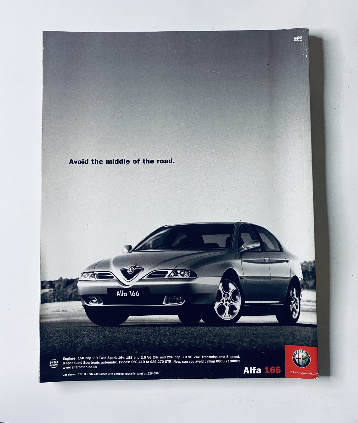 Alfa 166 advertisement with the slogan 'Avoid the middle of the road.' showcasing a sleek silver car design. Featured in CAR Magazine September 2001.