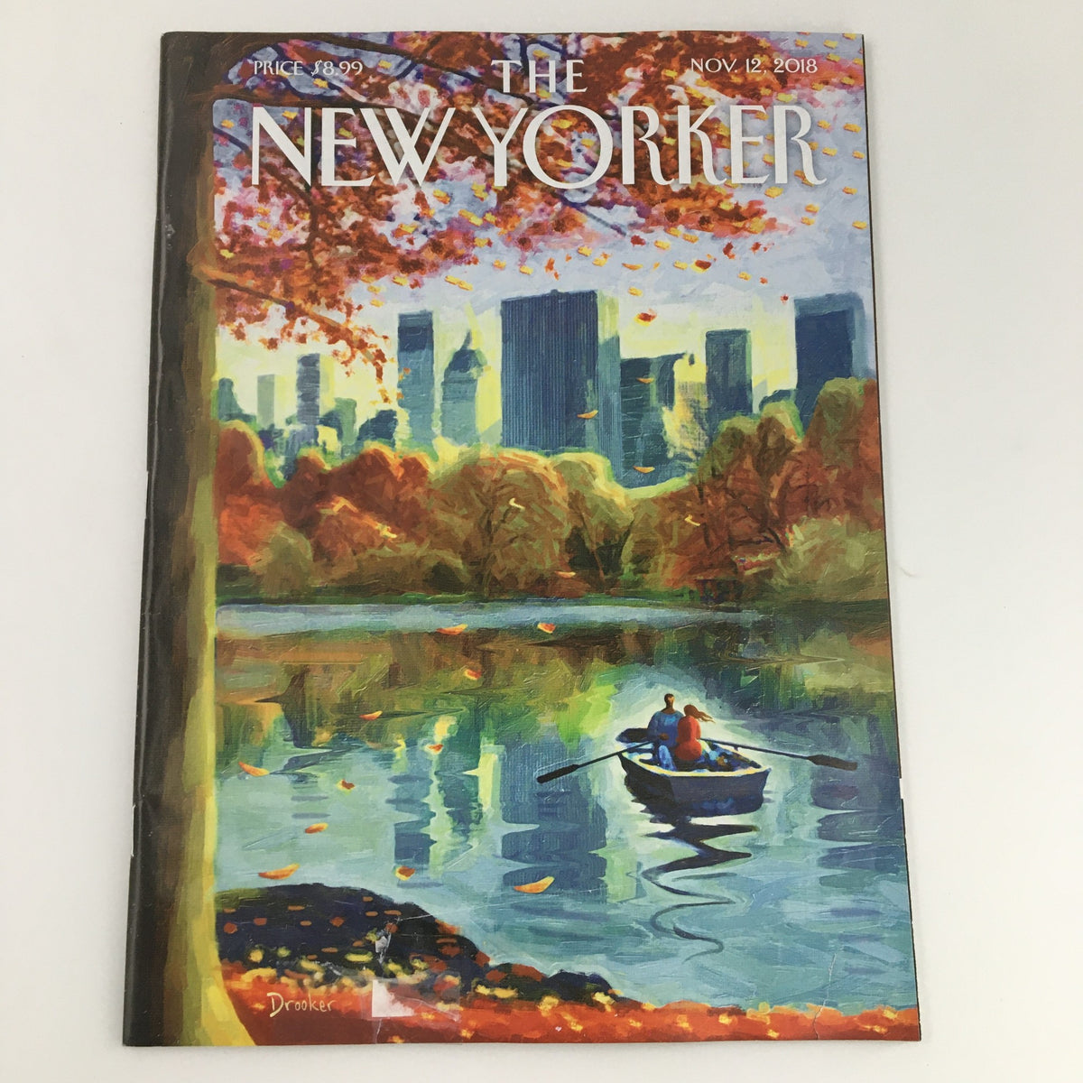 The New Yorker November 12 2018 Full Magazine Cover featuring Eric Drooker's artwork depicting a serene autumn scene with a boat on a reflective lake and a city skyline in the background.