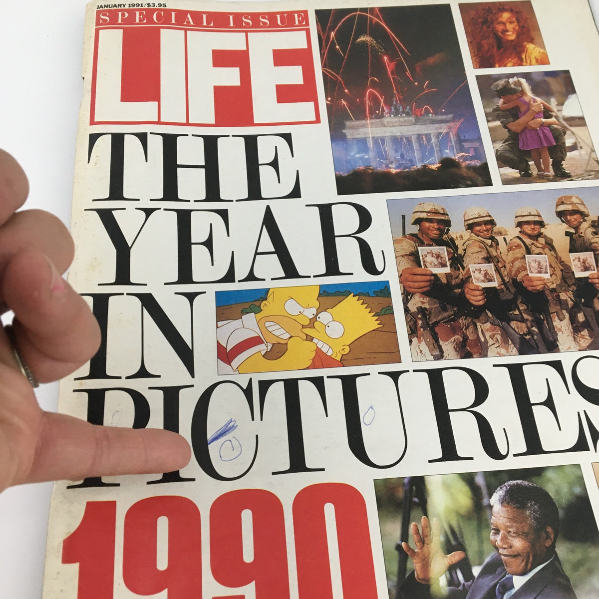 Close-up of the Life Magazine January 1991 cover titled 'The Year in Pictures of The Year 1991', emphasizing the title and images of historical significance from 1990, including cartoon and military references.