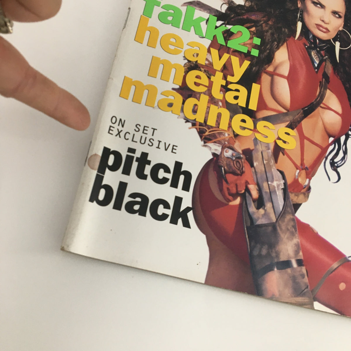 Close-up of the cover of Sci-Fi Channel Original Magazine February 2000 highlighting 'Heavy Metal Madness' and an exclusive feature on 'Pitch Black,' with a person's finger pointing at the text.