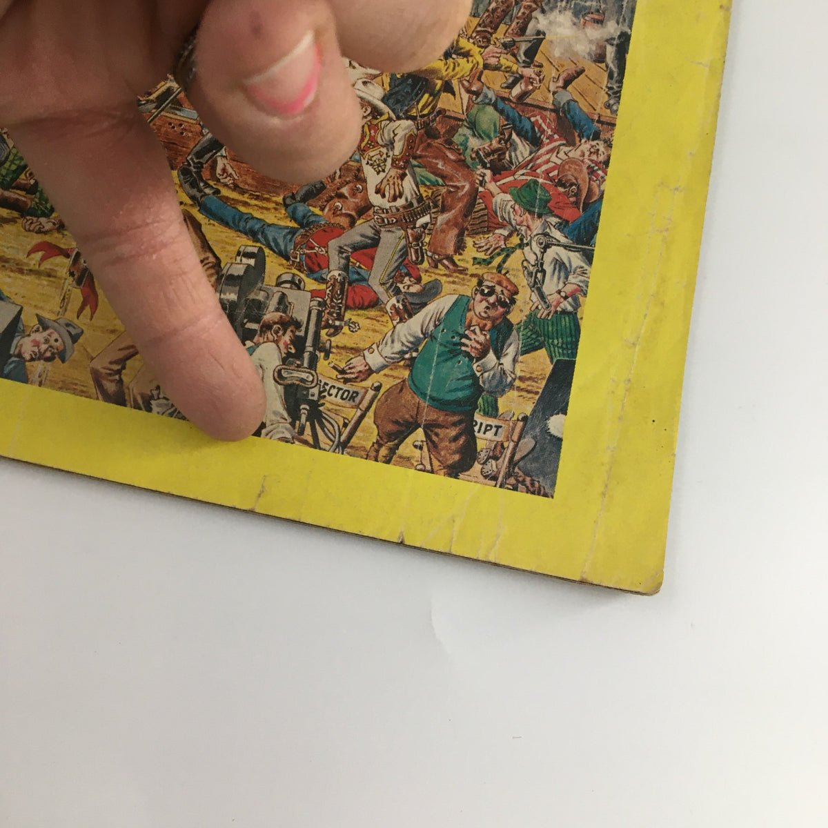 Detail of VTG Cracked 1980 Collector's Edition Cracked Goes To The Movies, Newsstand showing edge wear and a pointing finger indicating damage on the cover.