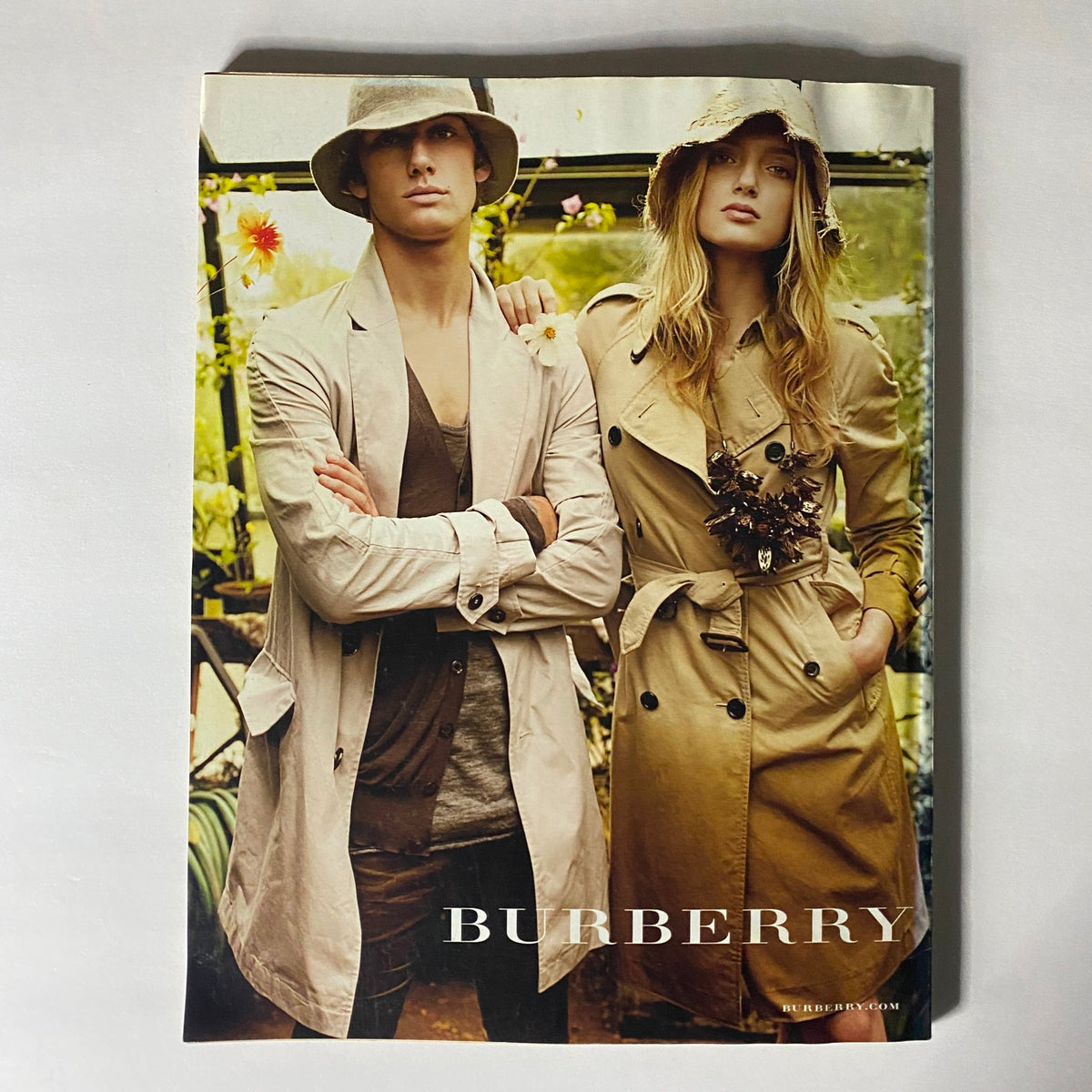 Promotional page for Burberry from W Magazine February 2009, displaying stylish models in fashionable trench coats, reflecting early 2000s fashion.