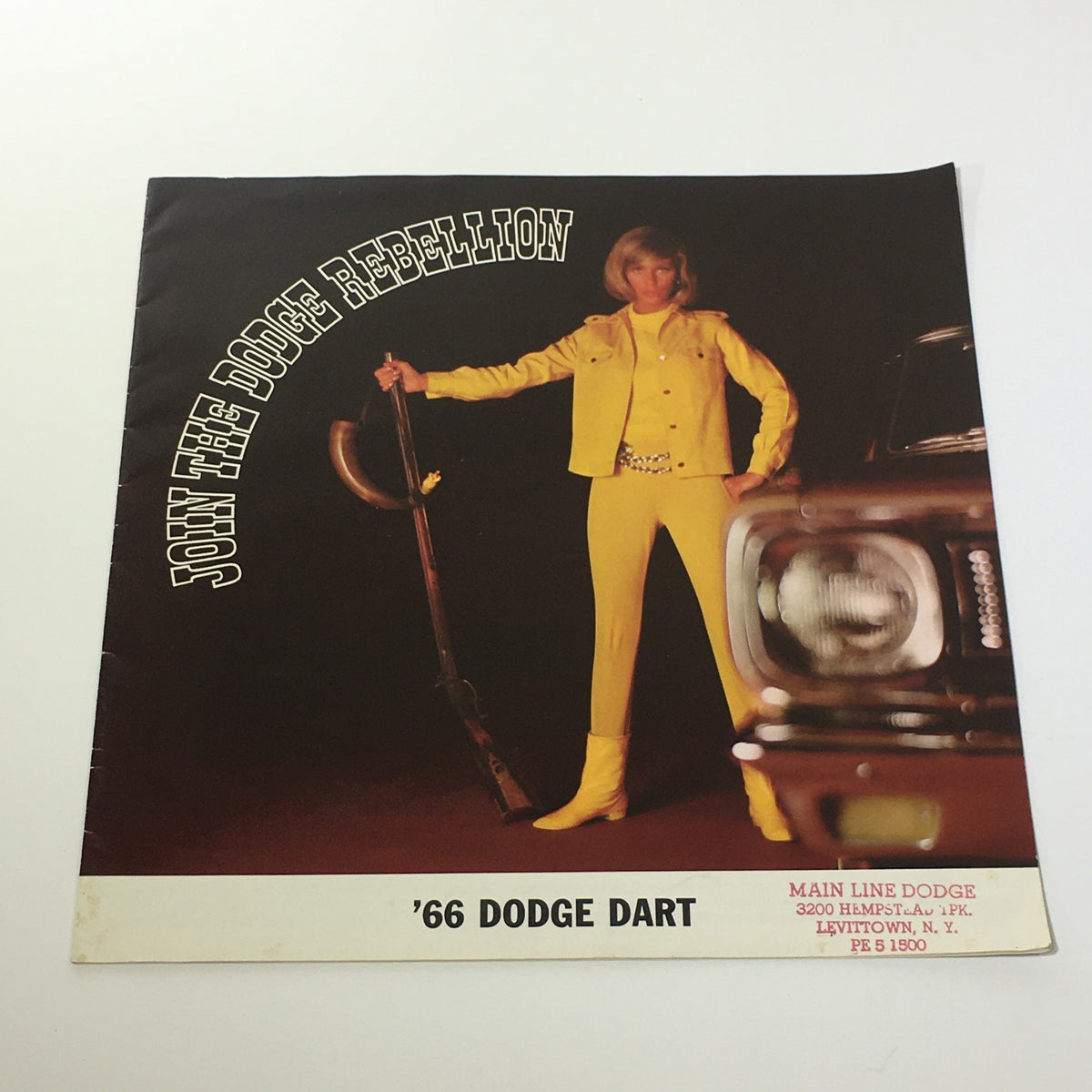 1966 Dodge Dart V-8 Engine 4-Speed Gearbox 2-Door Sedan Car Sale Brochure cover featuring a model in a yellow outfit holding a rifle, promoting the Dodge Dart with the tagline 'Join the Dodge Rebellion'.