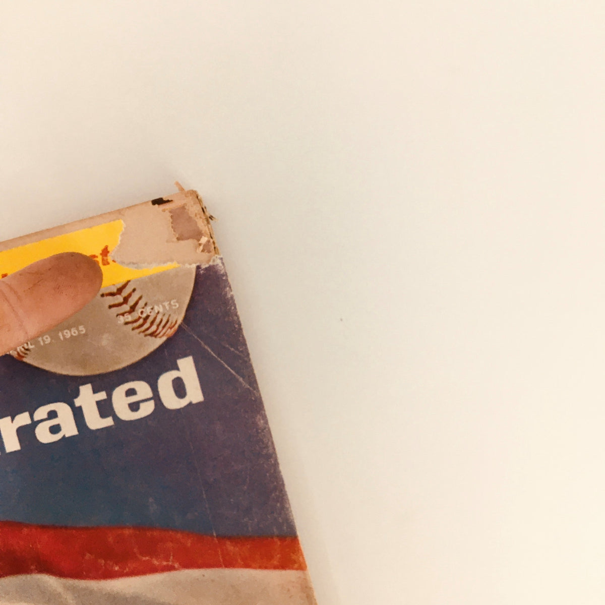 Detail of the top edge of the Vintage Sports Illustrated magazine from April 19, 1965, with visible wear, featuring the title 'Sports Illustrated' and the date.