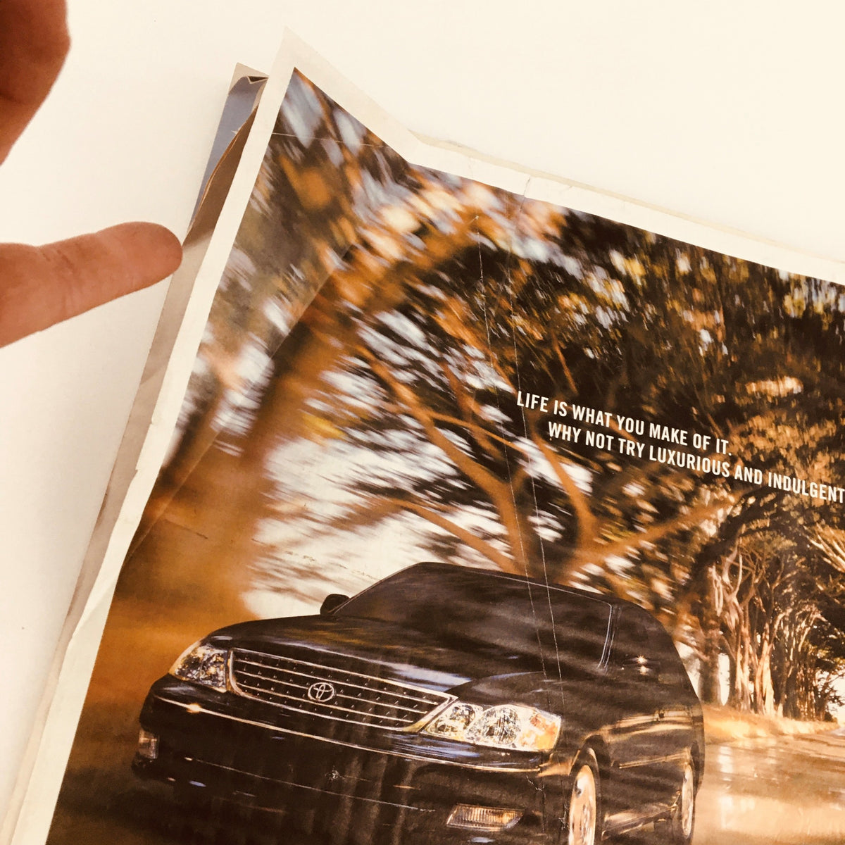 Close-up of Toyota advertisement from The New York Times Magazine March 28, 2004, showcasing the 2004 Avalon with a scenic background.