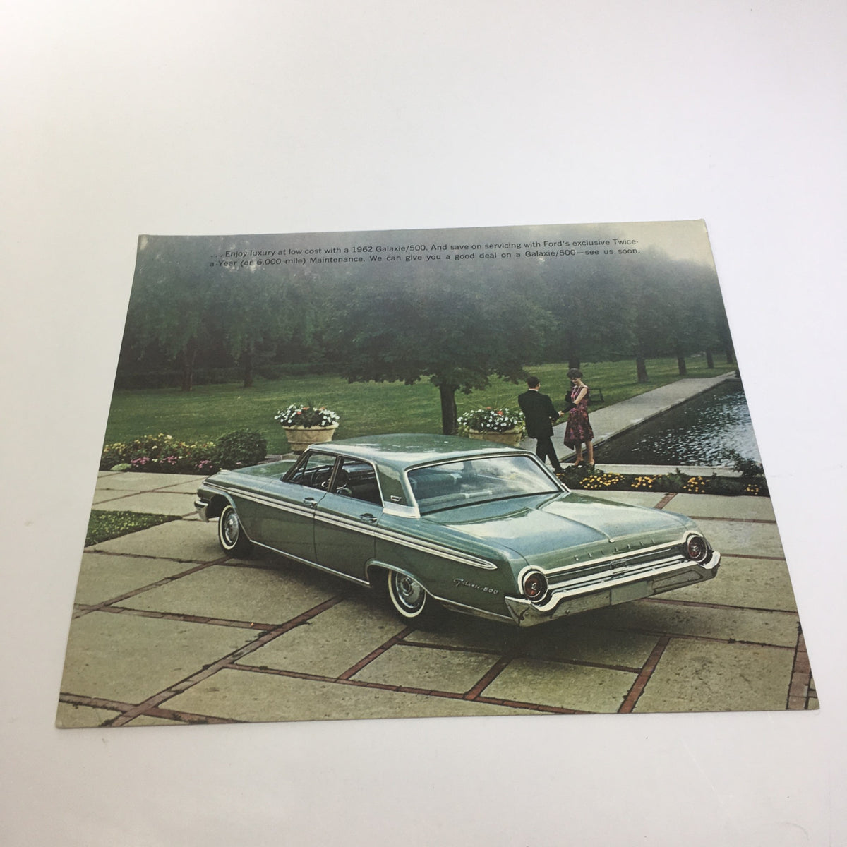 1962 Ford Galaxie Town 500 4-Door Sedan brochure showcasing the vehicle parked in a lush garden setting with two individuals nearby.