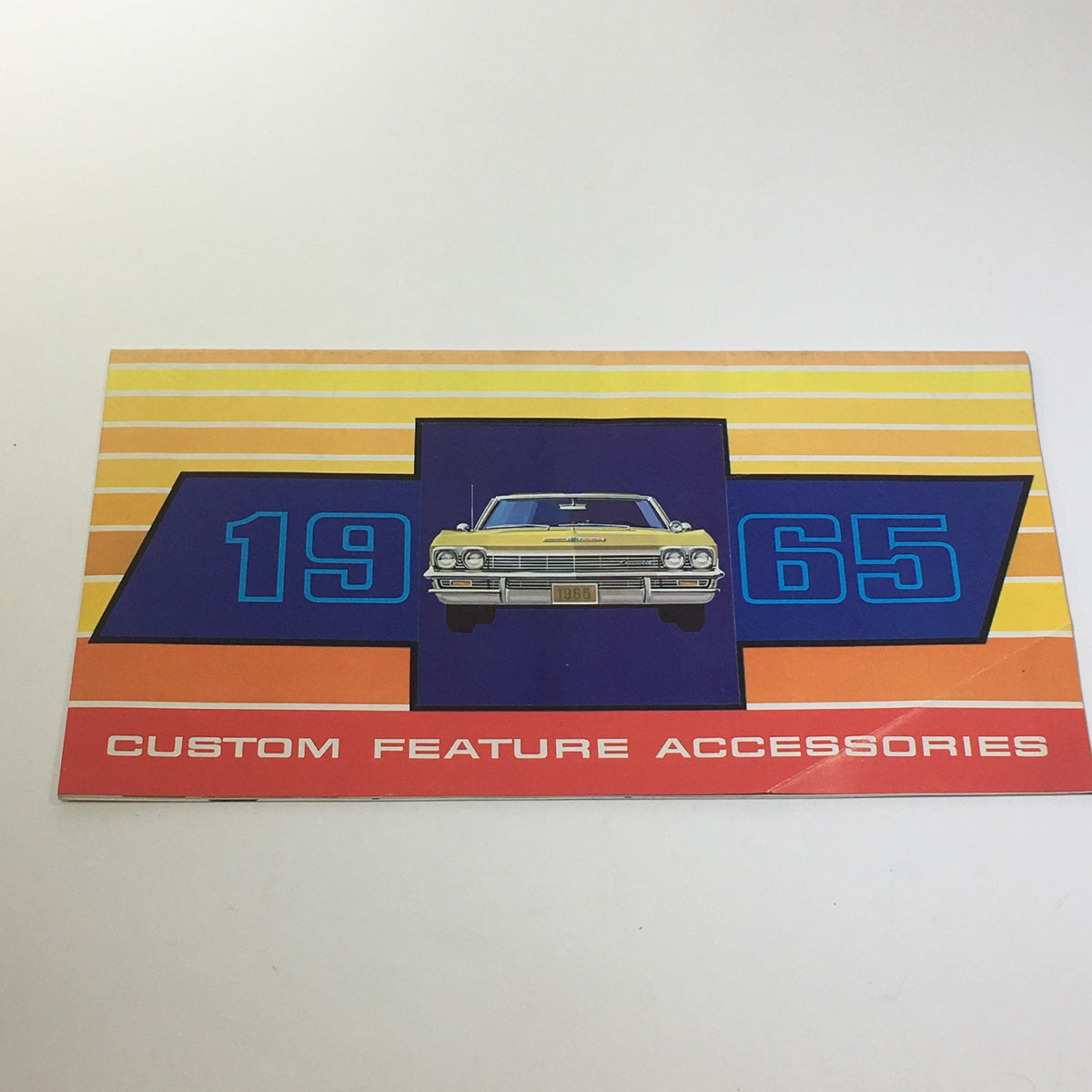 1965 Chevrolet Custom Feature Accessories Wire Wheel Cover Car Catalog Brochure cover showcasing a classic car design with bold colors and text.